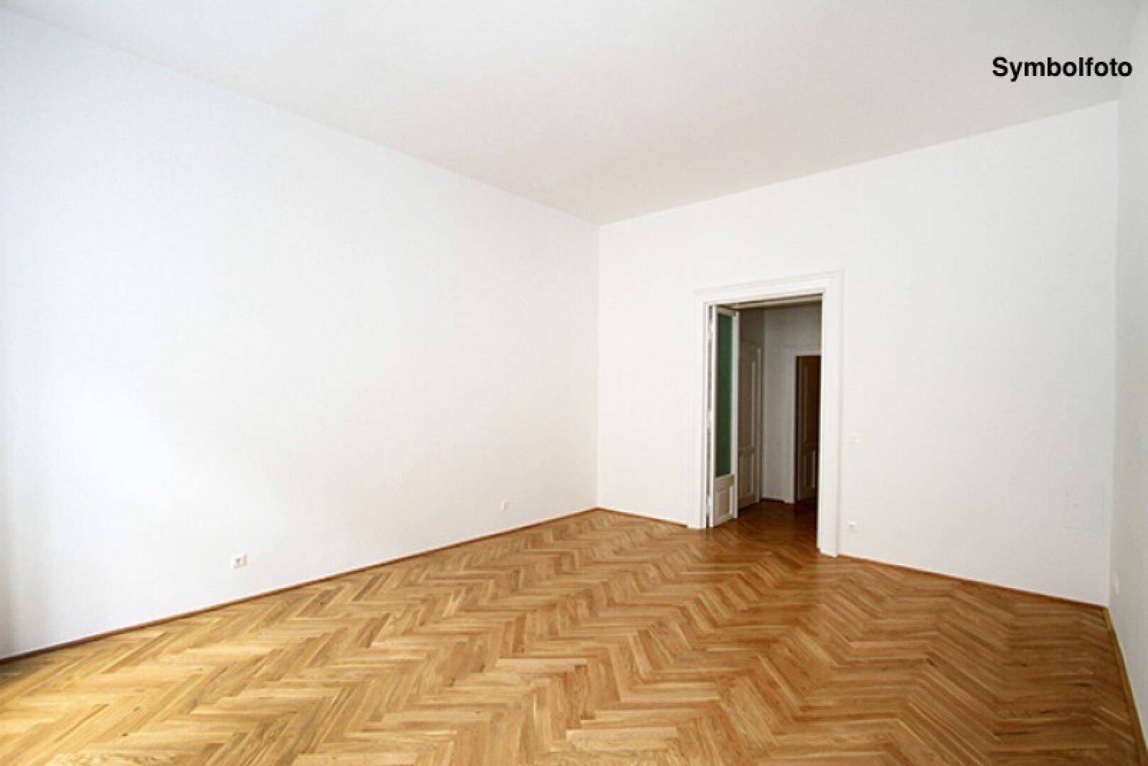 Heller Raum mit Fischgrätparkett und weiß gestrichenen Wänden, bereit zur individuellen Gestaltung.