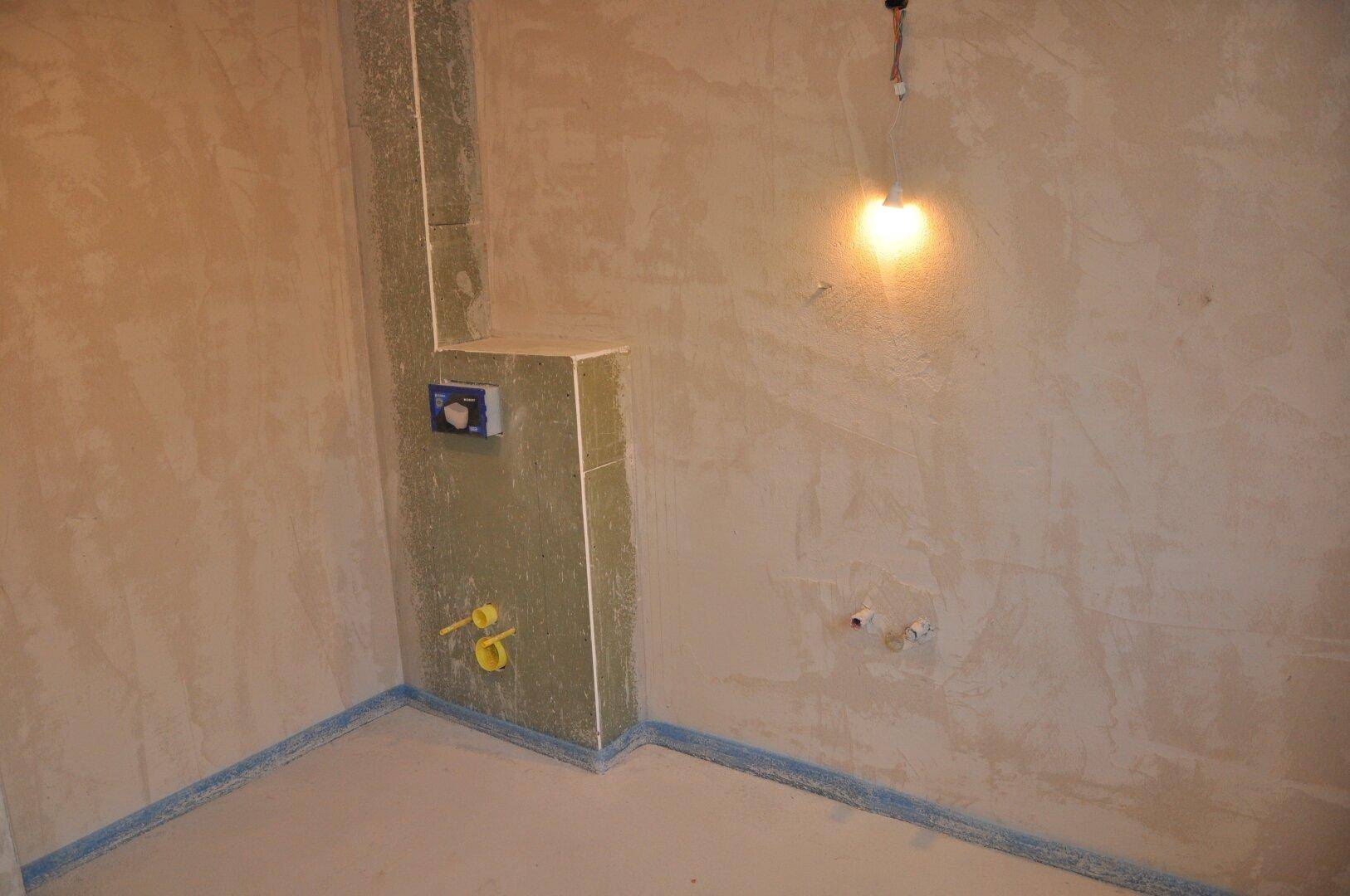 Unfertiges WC mit Vorwandinstallation für ein Wand-WC und vorbereiteten Wasseranschlüssen.