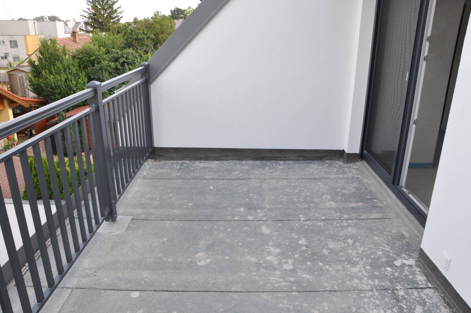Balkon mit schwarzem Metallgeländer und Schiebetür, bereit für die Endgestaltung.
