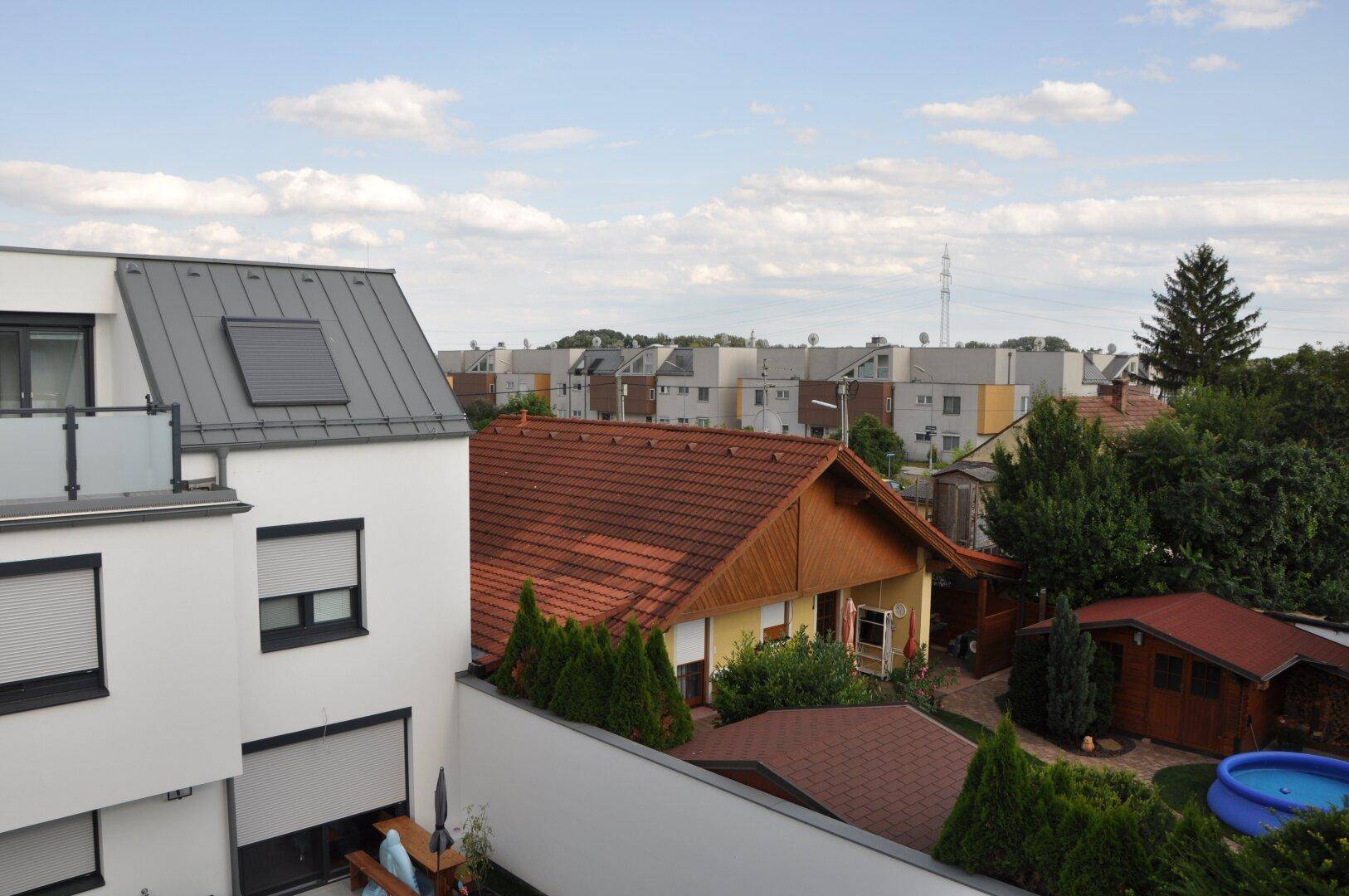 Ausblick vom Anwesen auf die Nachbarschaft mit Gärten, anderen Häusern und einem kleinen Pool.