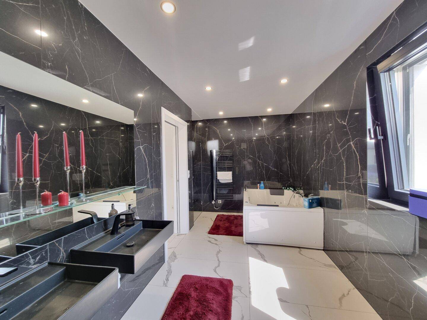 Geräumiges Luxusbad mit Doppelwaschbecken, beheiztem Handtuchhalter und Whirlpool-Badewanne.