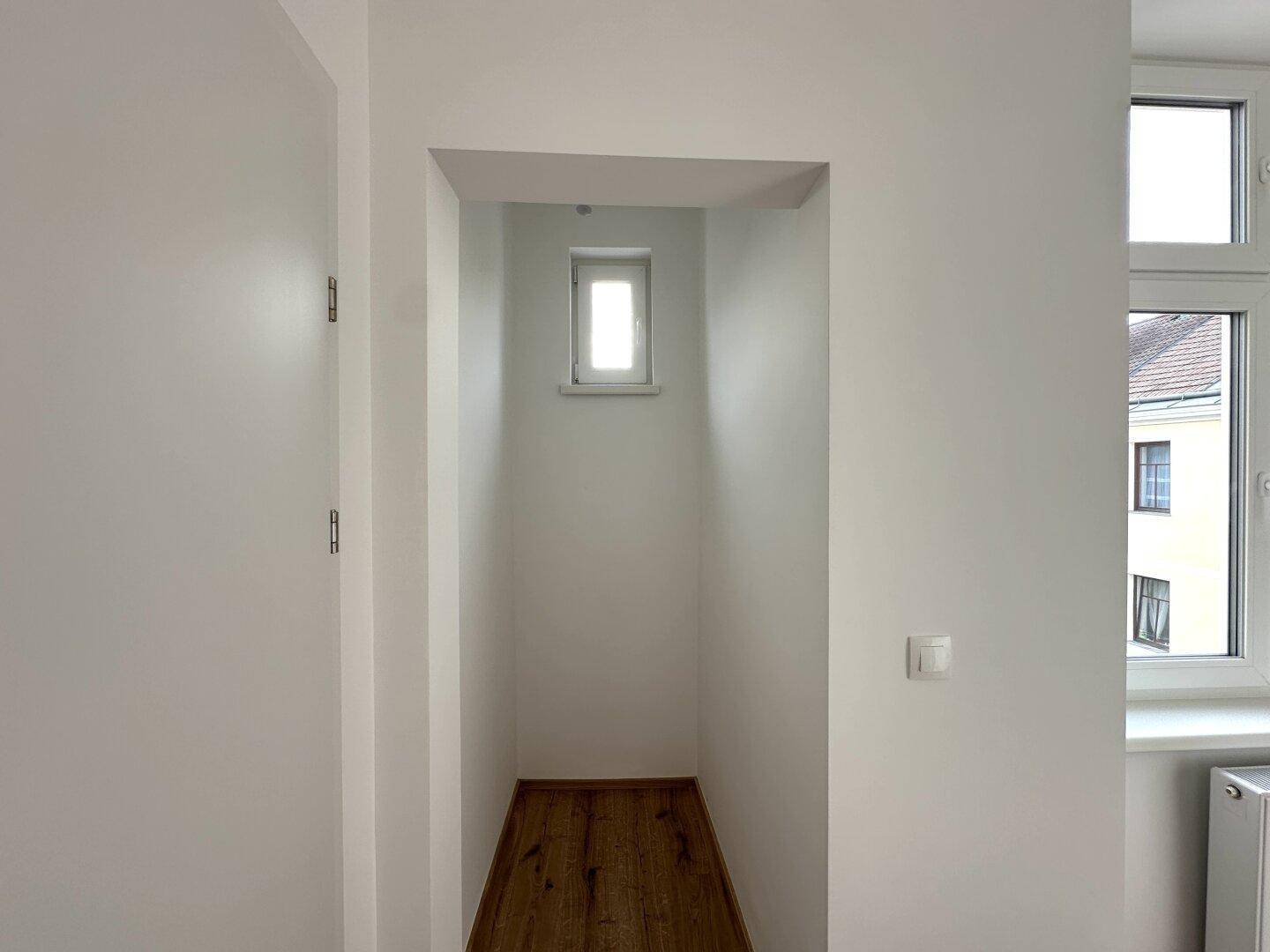 Kleine Nische oder Abstellraum mit einem Fenster, ideal für zusätzlichen Stauraum.