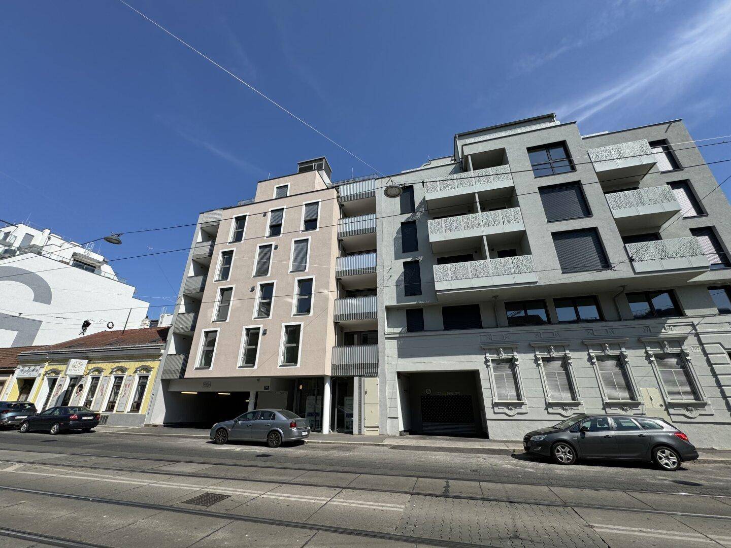 Fassade eines modernen Wohngebäudes mit unterschiedlichen Farbtönen und Balkonen.