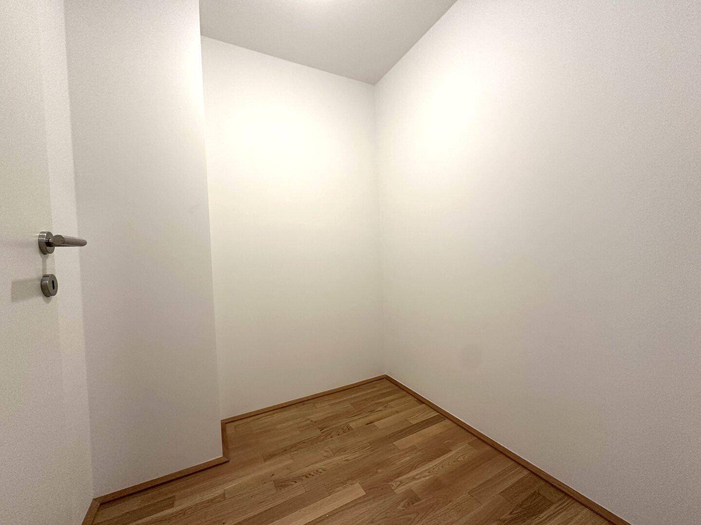 Kleiner, heller Abstellraum mit Holzboden, bietet flexible Nutzungsmöglichkeiten für Lagerung.
