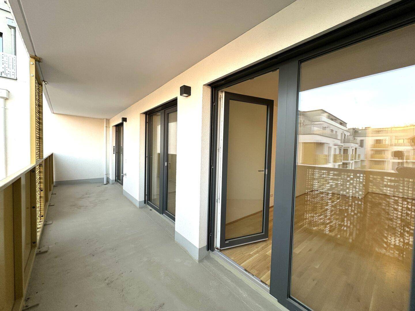 Geräumiger Balkon mit Blick auf die Umgebung und moderne Architektur des Gebäudes.