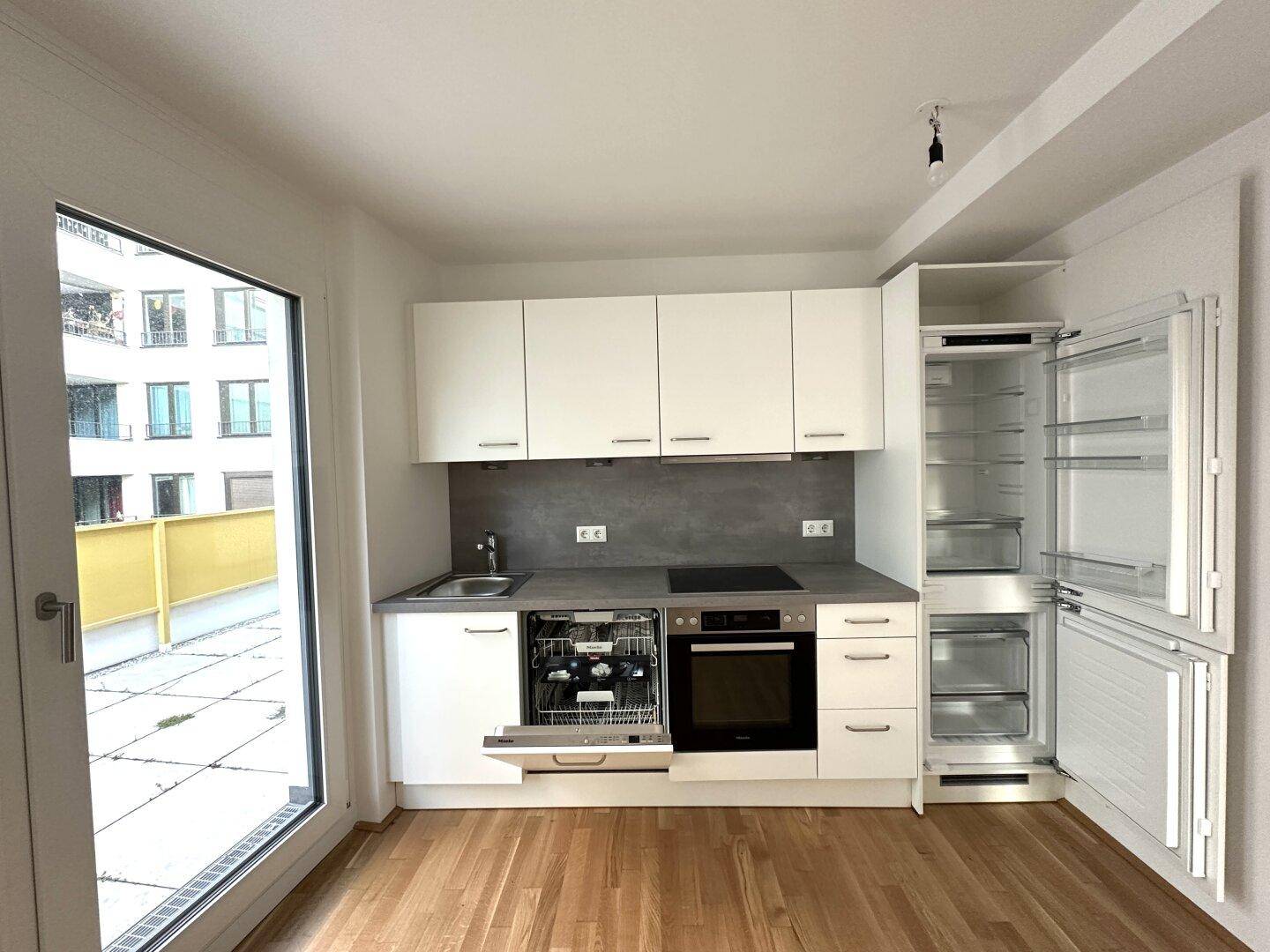 Voll ausgestattete moderne Küche mit Geschirrspüler, Kühlschrank und Gefrierfach.