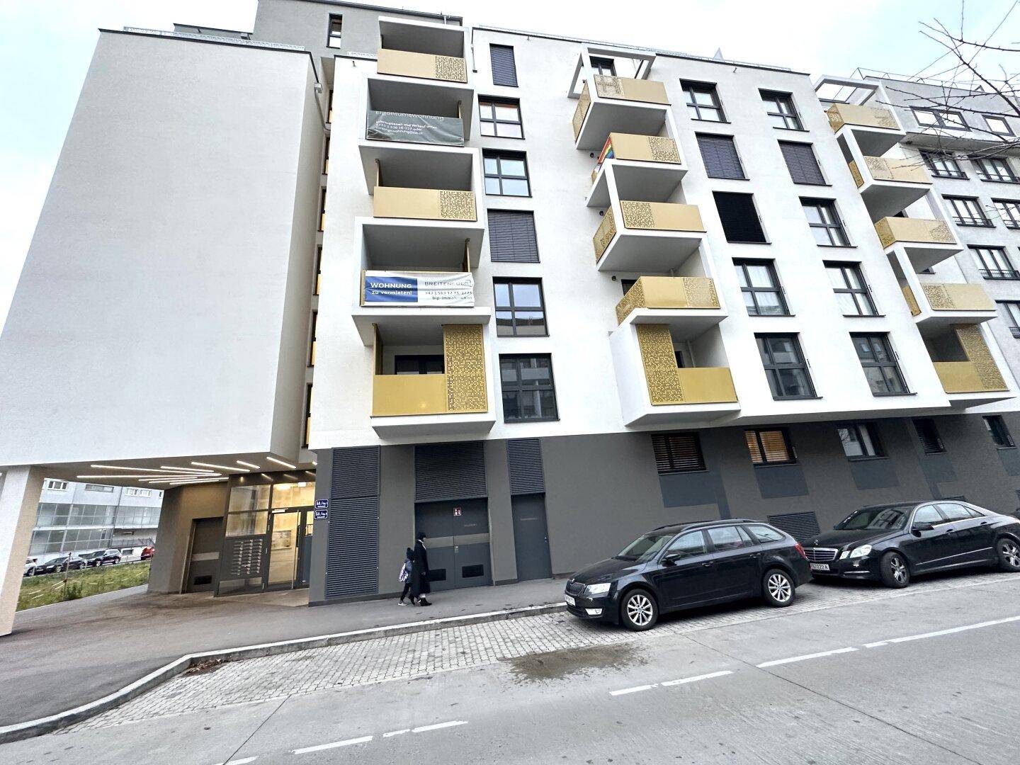 Gemeinschaftlicher Außenbereich mit Spielplatz und Sitzbänken zwischen modernen Wohngebäuden.