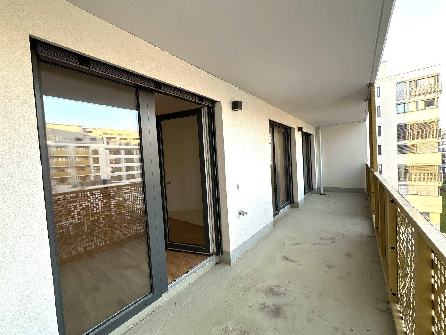 Geräumiger Balkon mit Schiebetüren zu den Innenräumen und modernem Design.