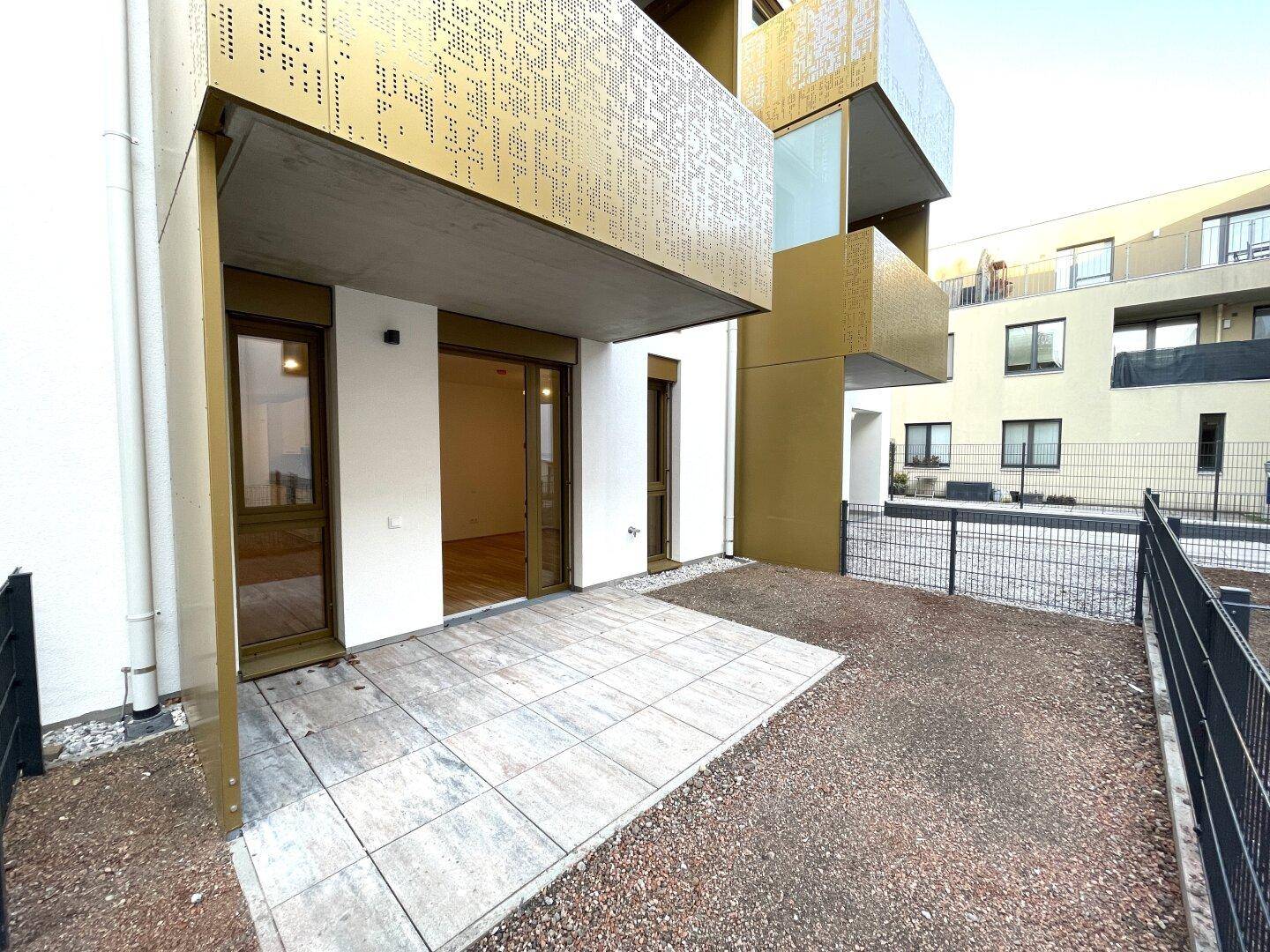 Moderne Terrasse mit Fliesenboden und Zugang zum Gartenbereich.