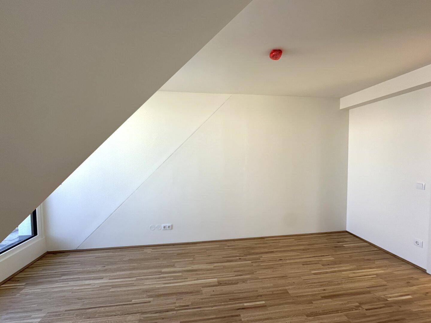 Schlafzimmer mit Parkettboden und Dachschräge, bietet eine gemütliche Atmosphäre.
