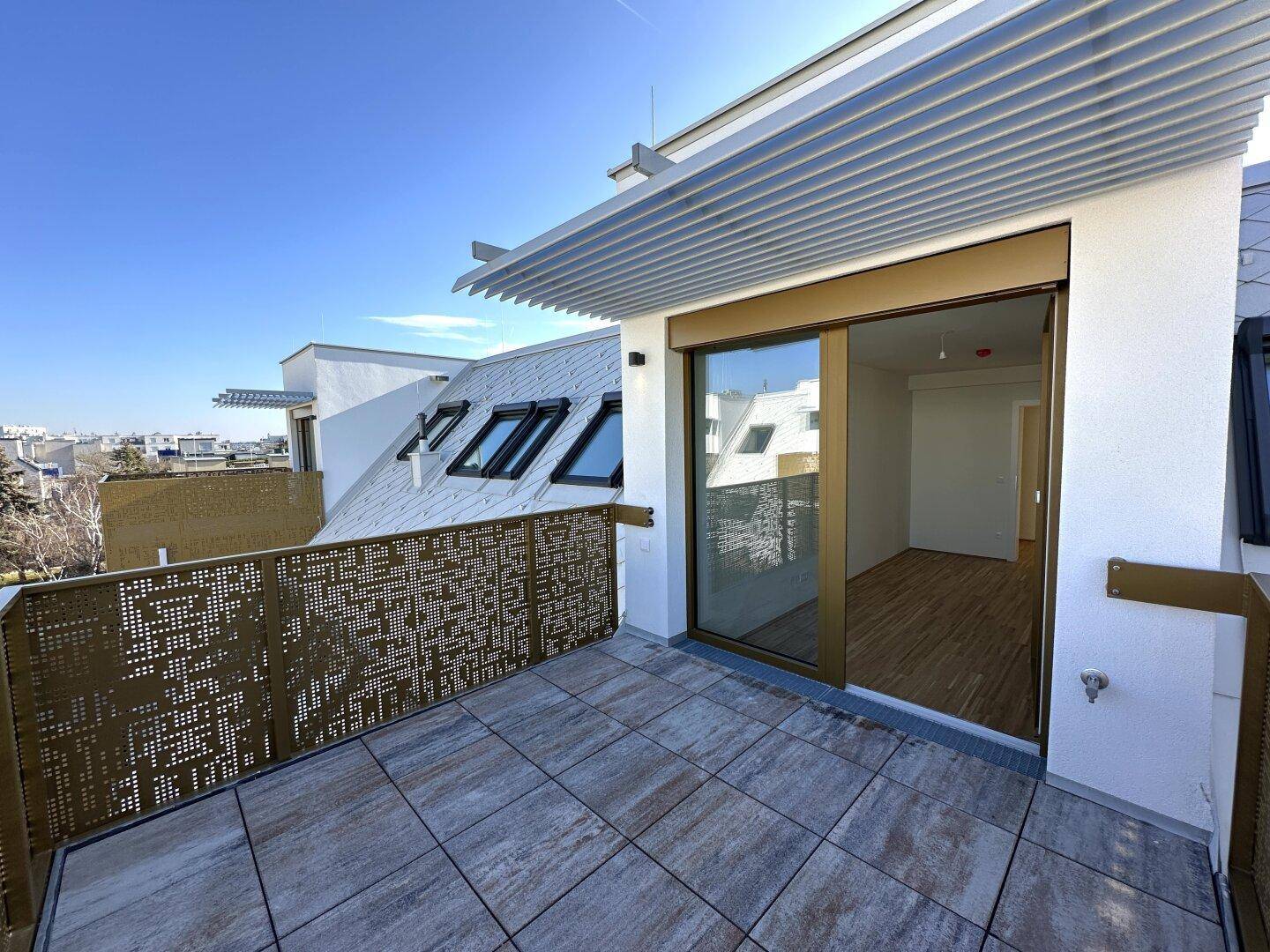 Sonnige Dachterrasse mit Schiebetürzugang zum Innenbereich und modernem Design.