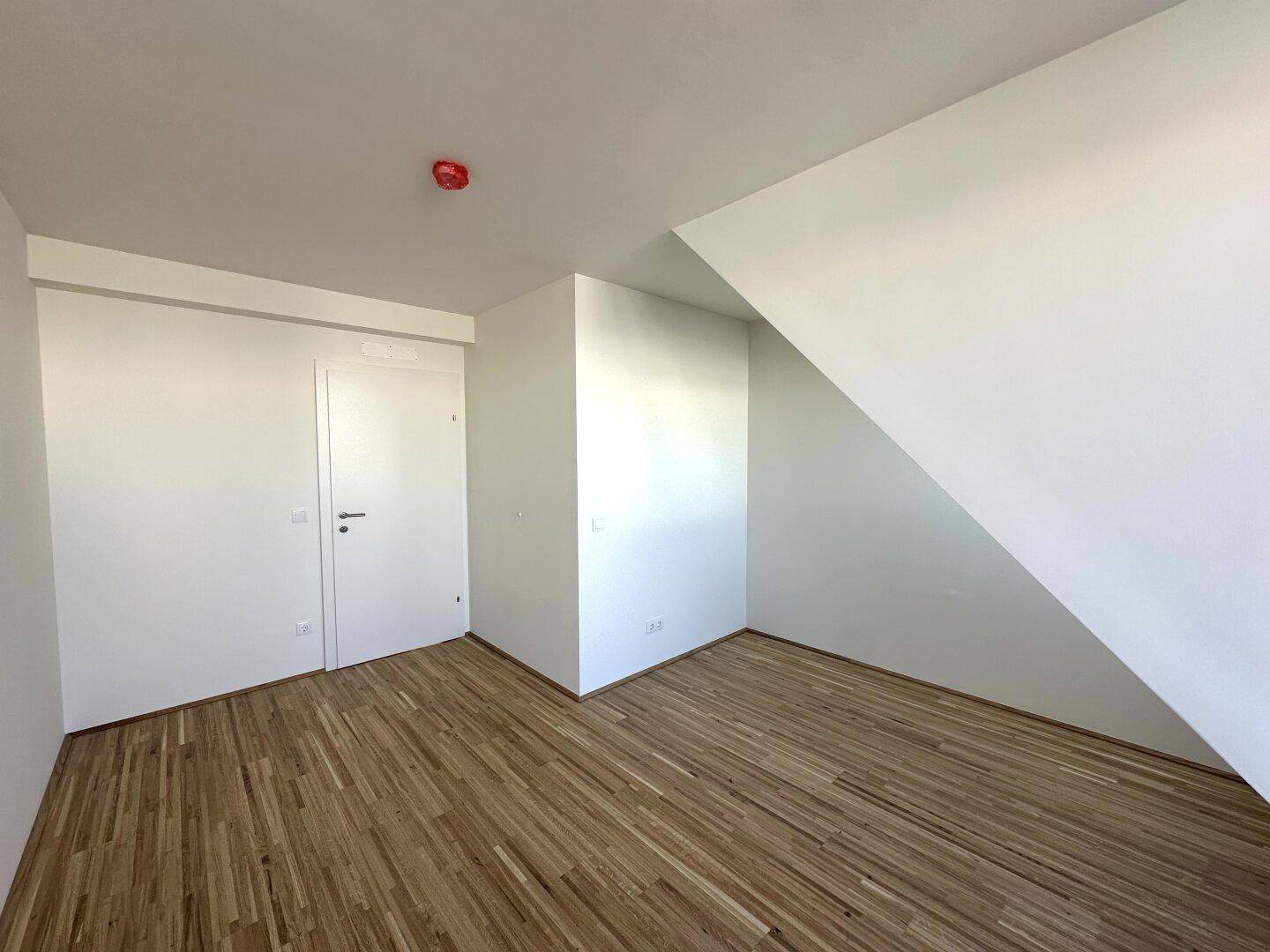 Helles Schlafzimmer mit Parkettboden und Einbauschränken, bietet viel Stauraum.