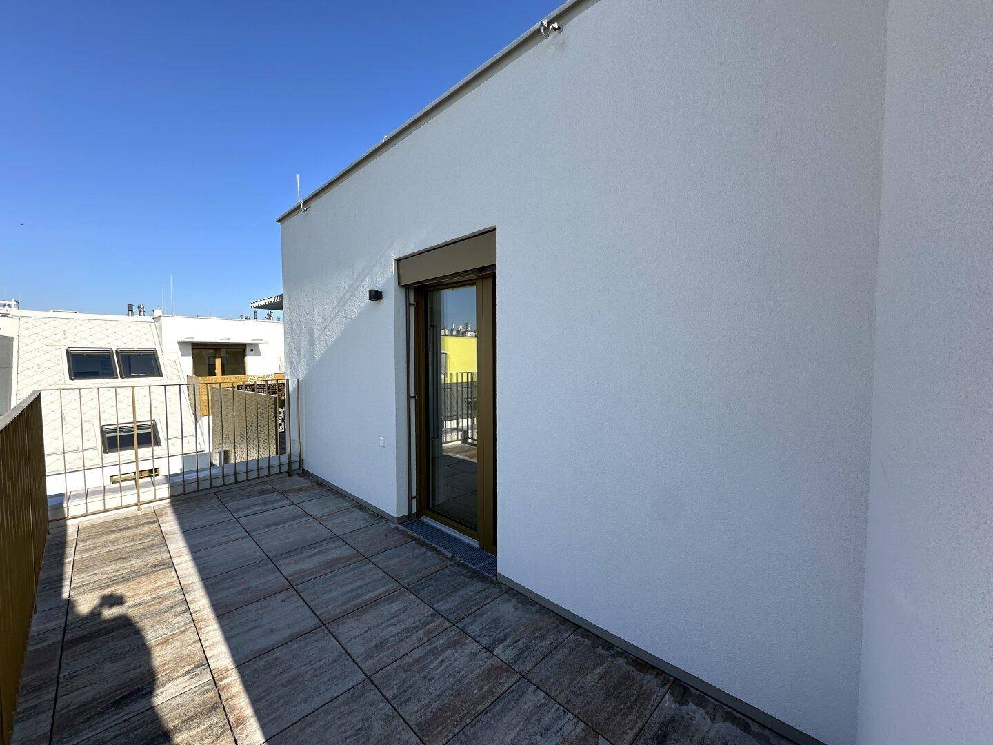 Dachterrasse mit Schiebetürzugang zum Innenbereich und Blick auf die Umgebung.