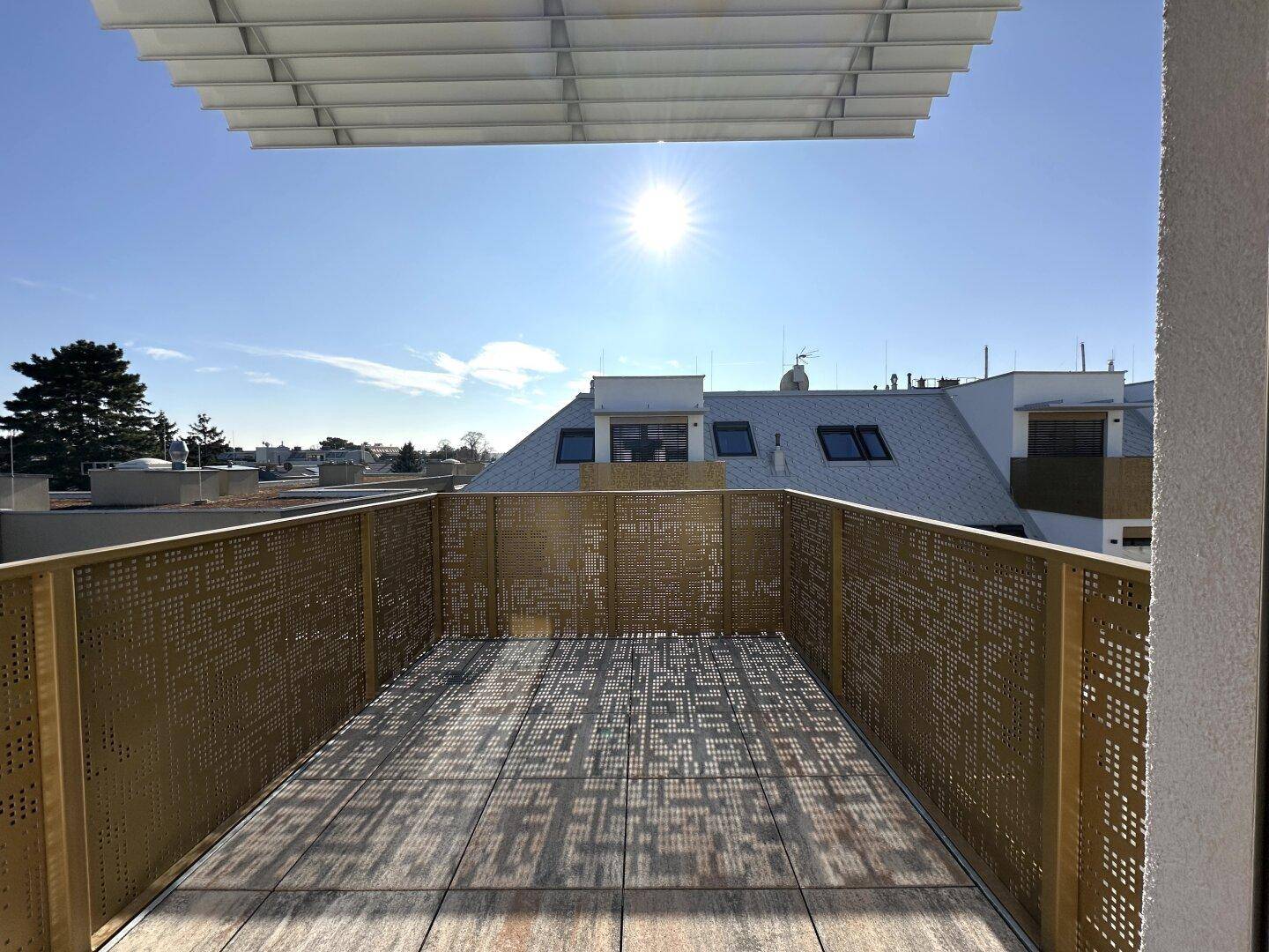 Sonnige Dachterrasse mit modernem Design und weitem Blick über die Dächer der Stadt.