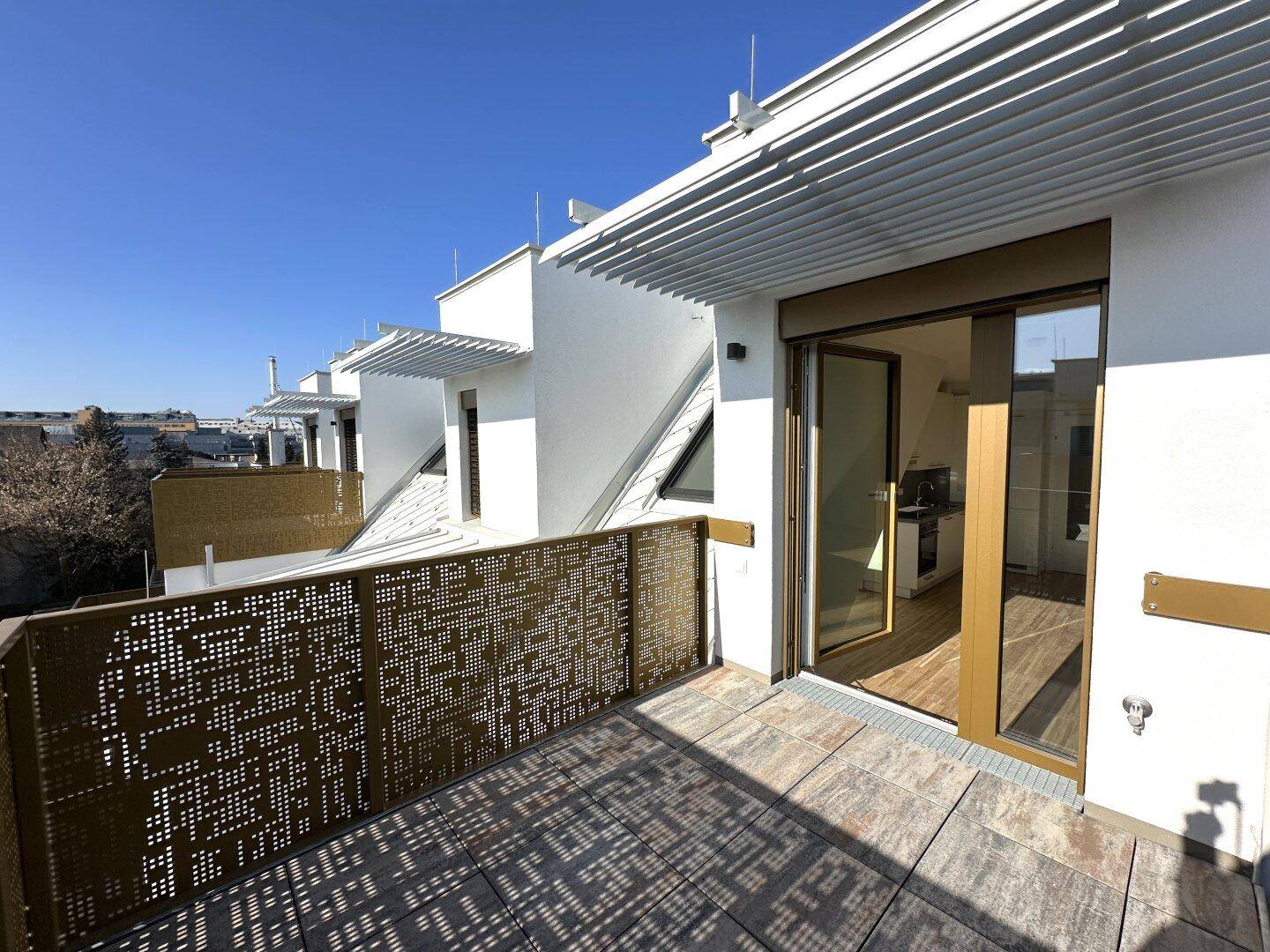 Geräumige Dachterrasse mit Schiebetüren zum Innenbereich und moderner Architektur.
