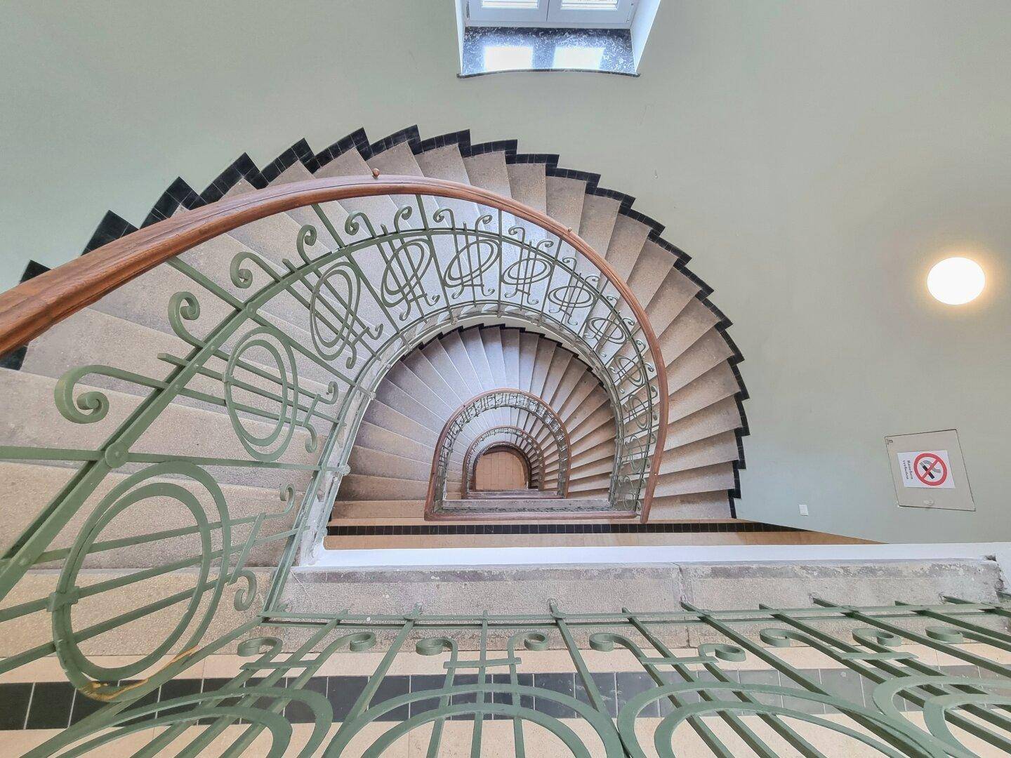 Beeindruckendes Wendeltreppenhaus mit kunstvollem Geländer, das die architektonische Eleganz hervorhebt.