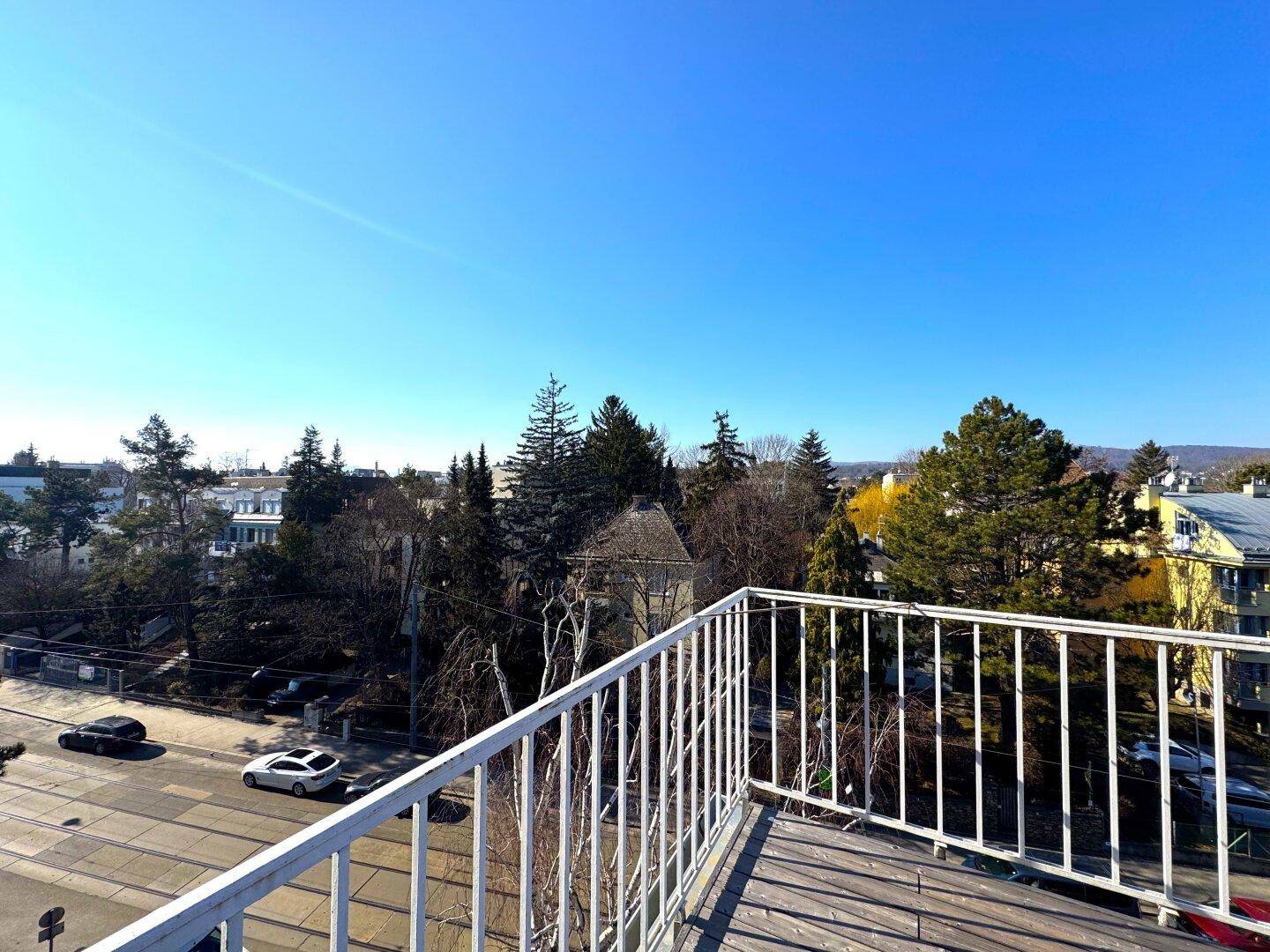 Panoramablick von der Dachterrasse auf die Straße, Bäume und die städtische Umgebung.