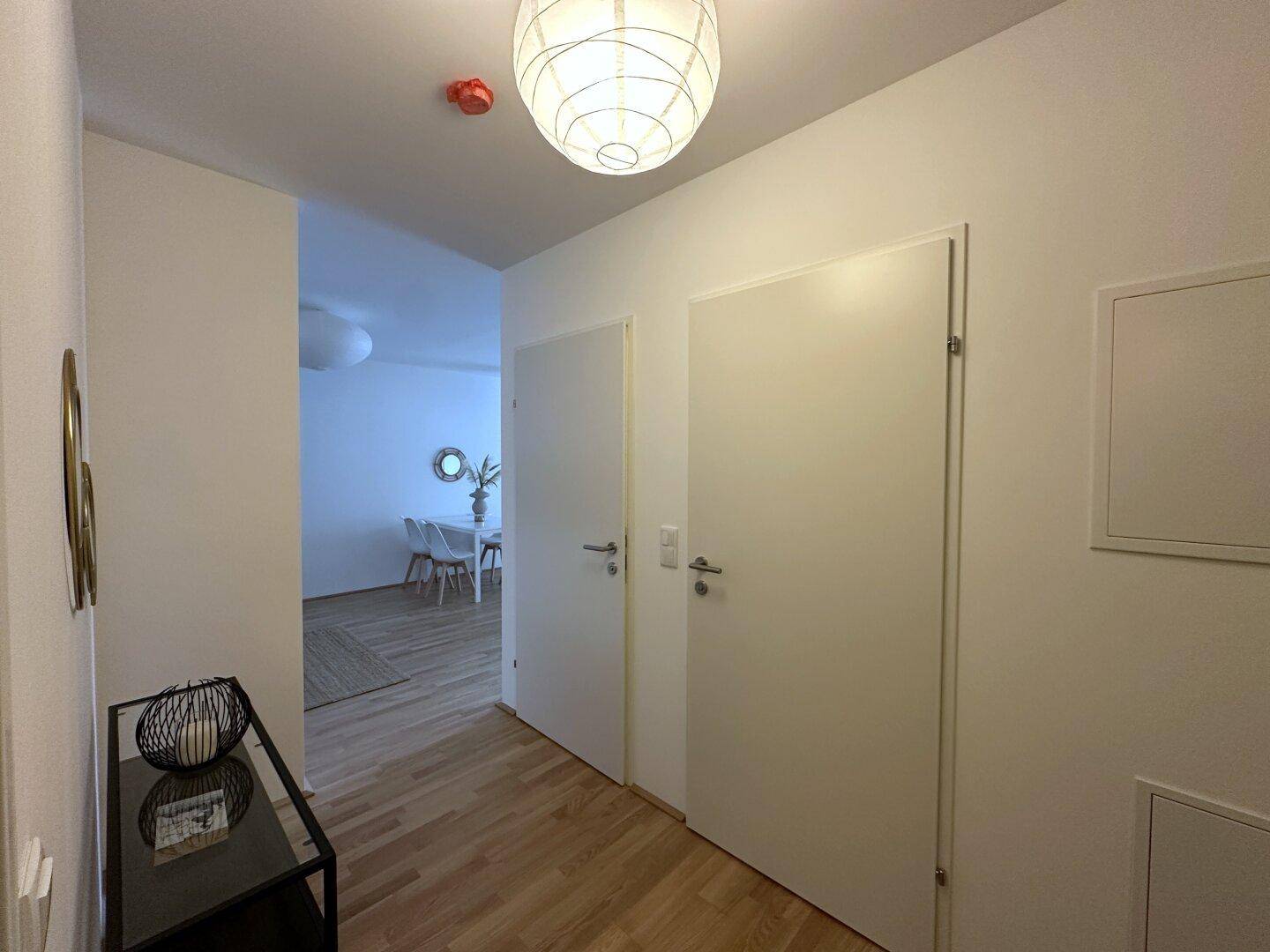 Eingangsbereich mit Holzboden und Zugang zu den verschiedenen Räumen der Wohnung.