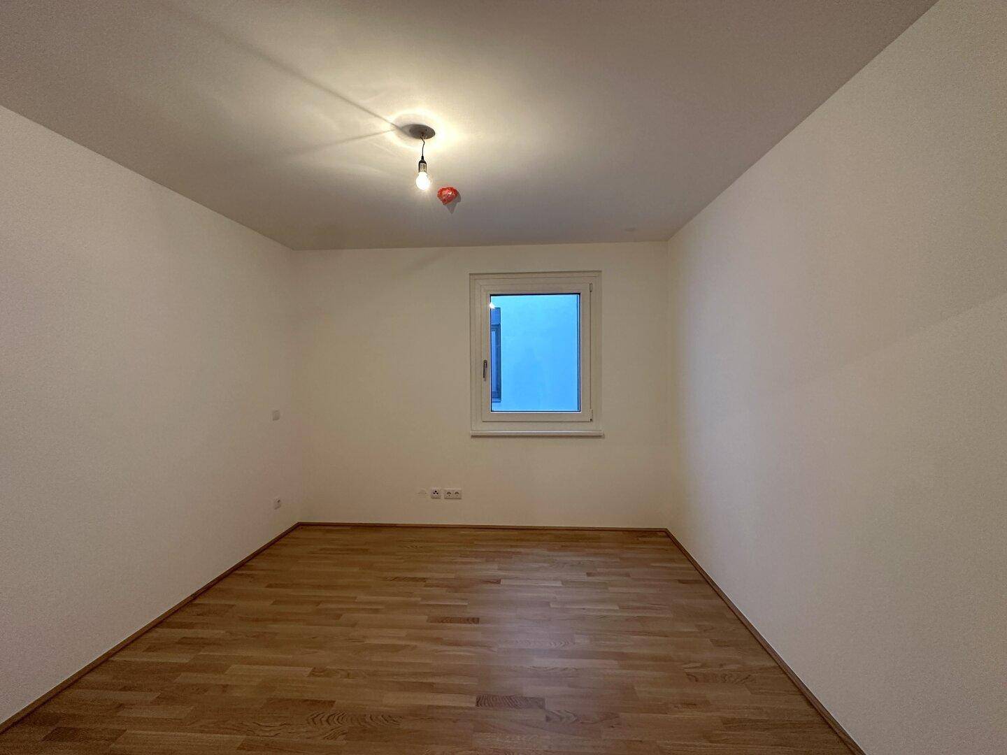 Helles Zimmer mit Parkettboden und Fenster, vielseitig nutzbar als Schlaf- oder Arbeitszimmer.