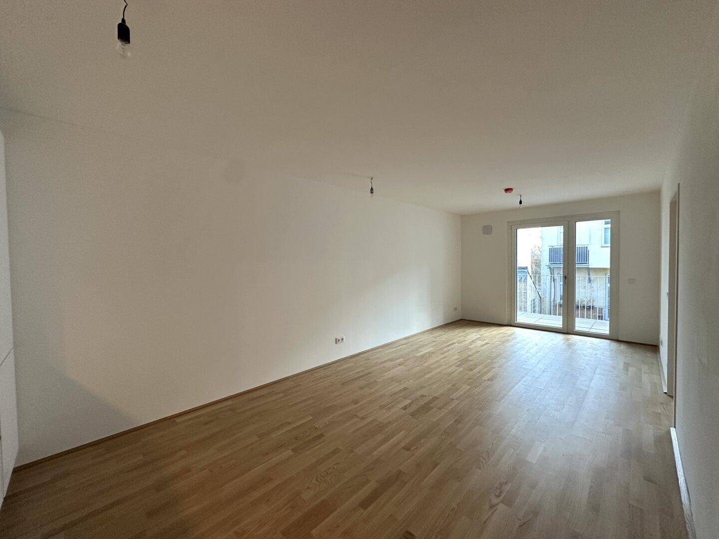 Heller Wohnraum mit Parkettboden und Blick auf den Außenbereich, bietet viel Gestaltungspotenzial.
