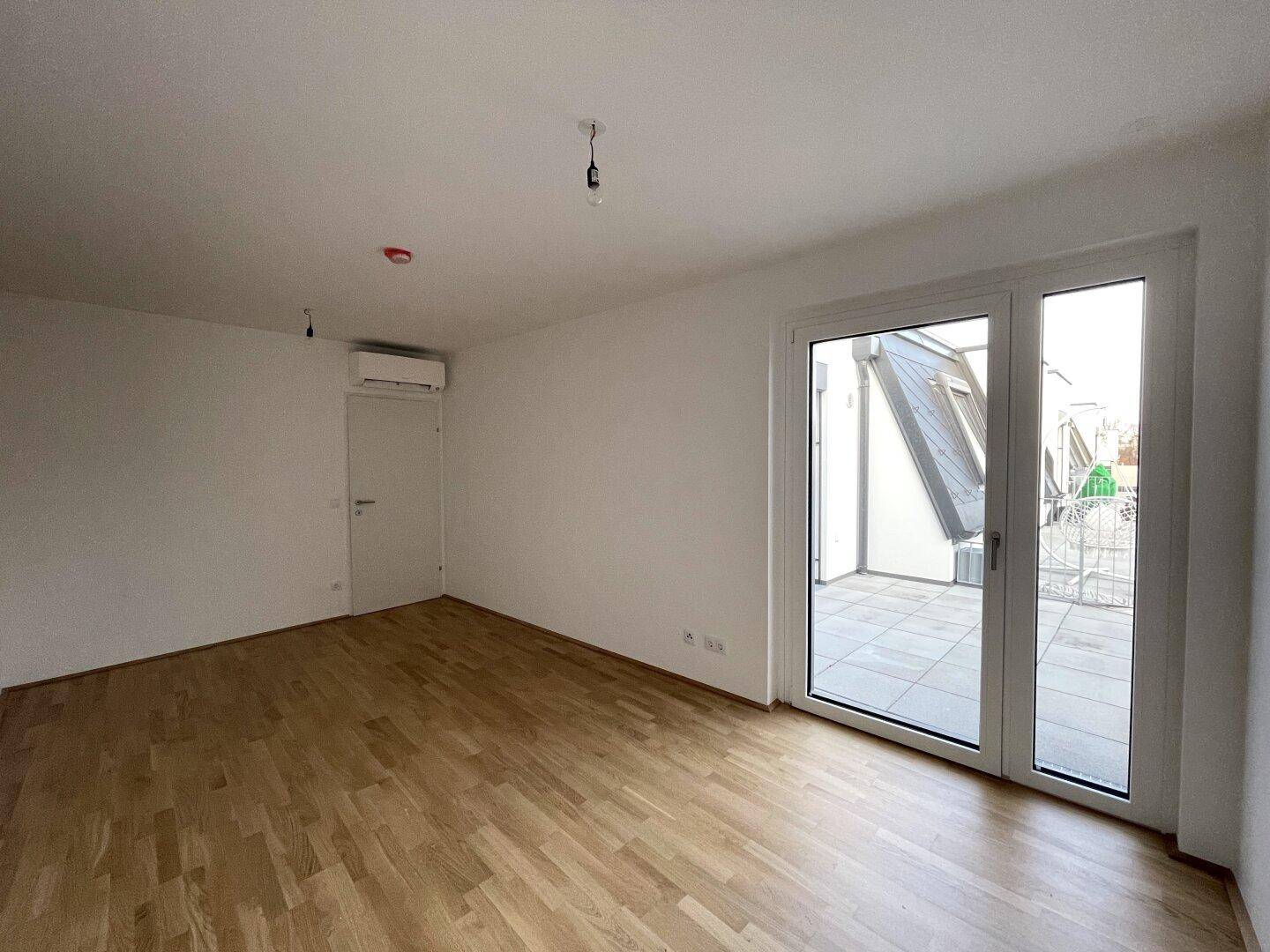 Geräumiges Schlafzimmer mit Klimaanlage und direktem Zugang zur Dachterrasse.