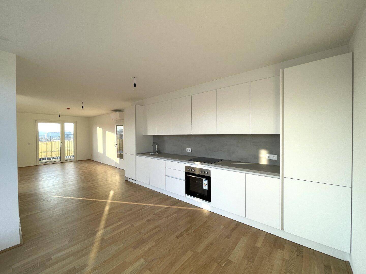 Geräumige, moderne Einbauküche mit weißen Fronten, integrierten Geräten und viel Stauraum.