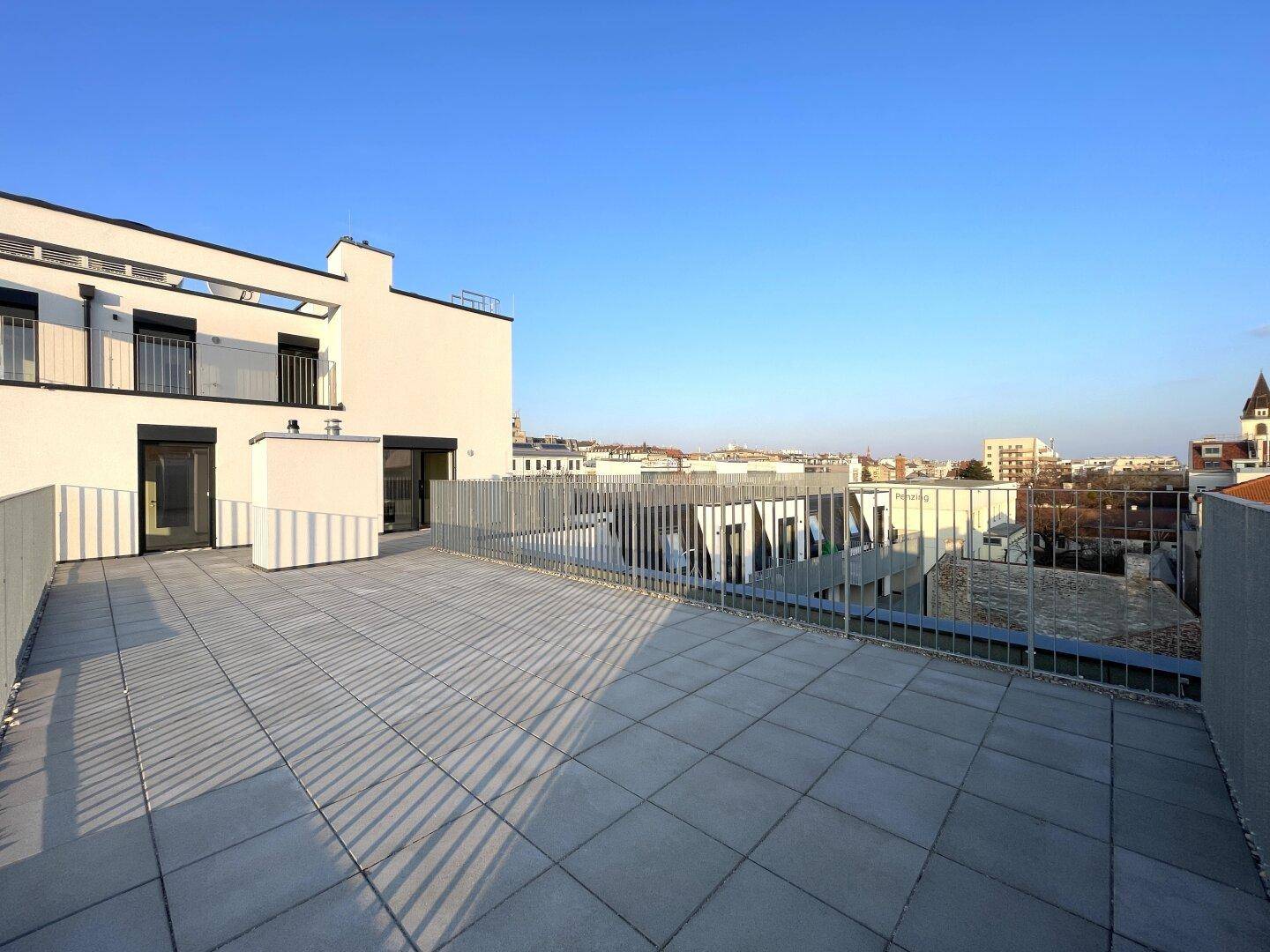 Moderne Dachterrasse mit klaren Linien und urbanem Ausblick, ideal für Entspannung.