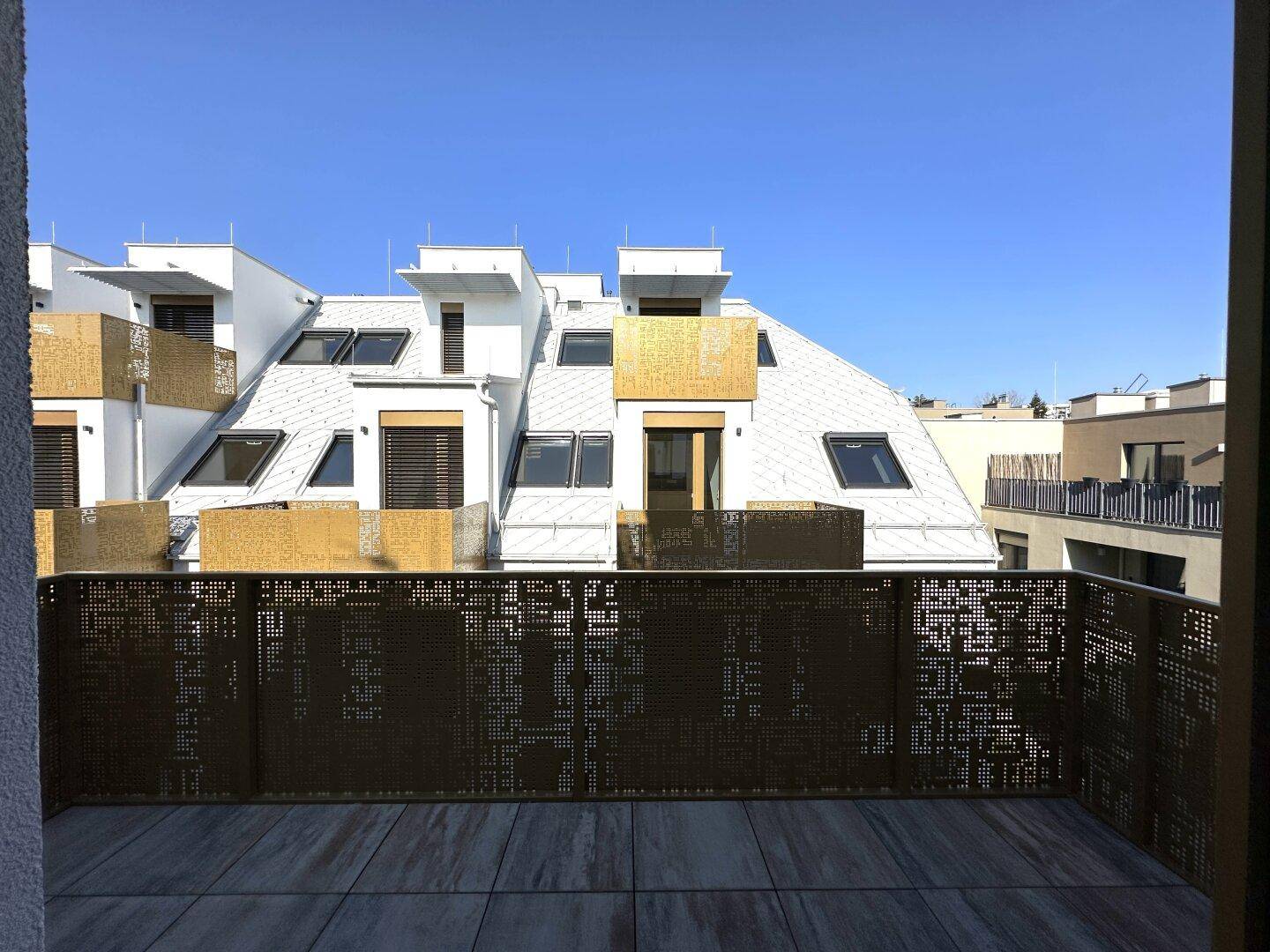 Geräumiger Balkon mit Fliesenboden und dekorativem Metallgeländer, Blick auf die Umgebung.