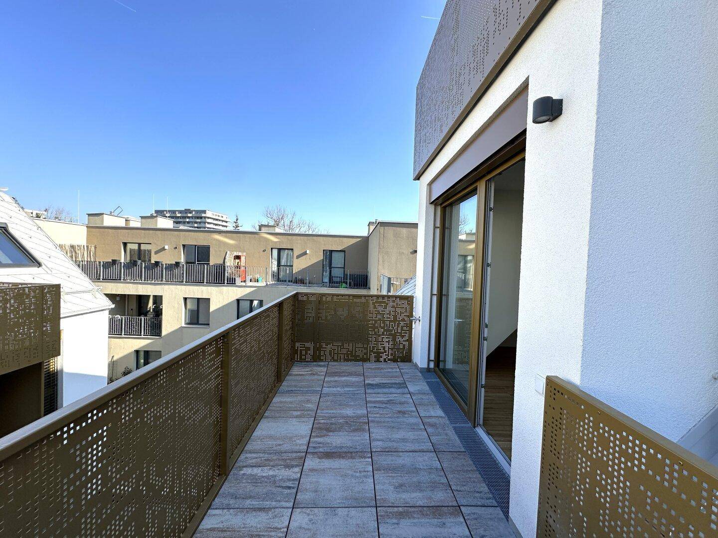 Langer Balkon mit Fliesenboden und modernem Geländer, ideal für Entspannung im Freien.