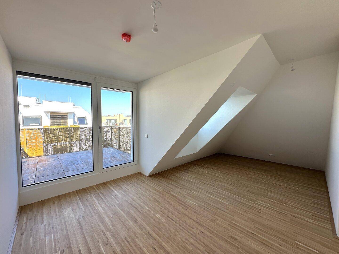 Helles Schlafzimmer mit Parkettboden, großen Fenstern und direktem Terrassenzugang für frische Luft.