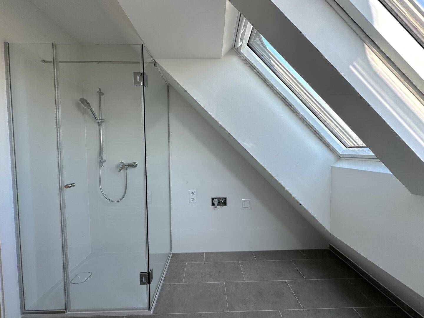 Modernes Badezimmer mit ebenerdiger Dusche und Dachschräge, funktional und stilvoll gestaltet.