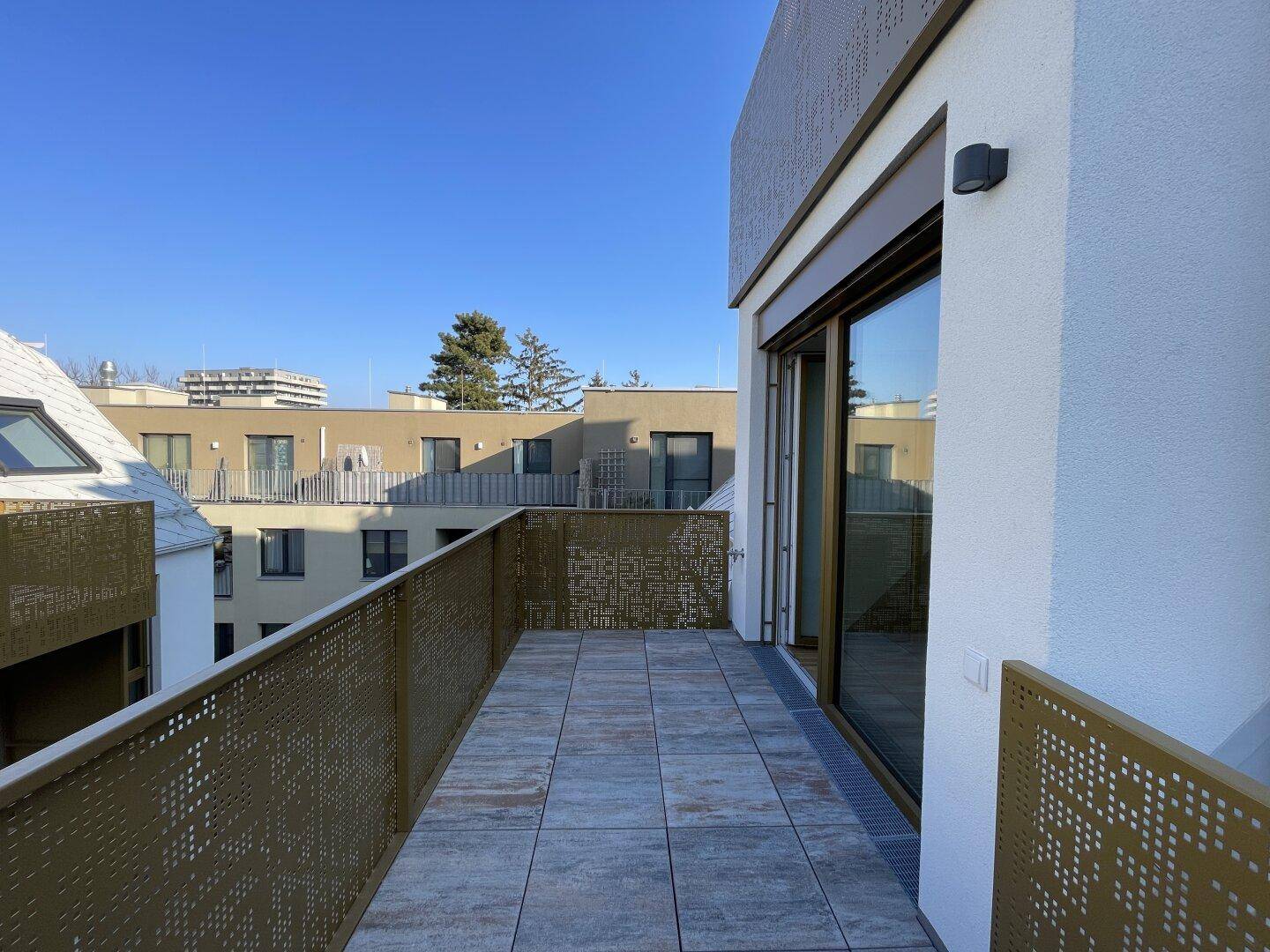 Geräumiger Balkon mit Fliesenboden und moderner Metallbrüstung, bietet einen weiten Blick über die Umgebung.