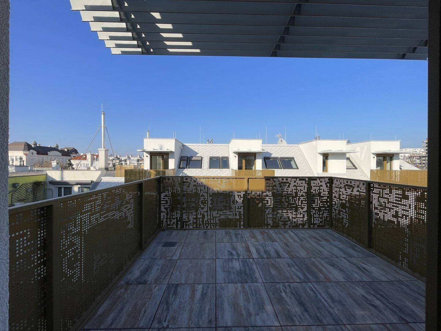 Geräumige Dachterrasse mit Fliesenboden und moderner Metallbrüstung.