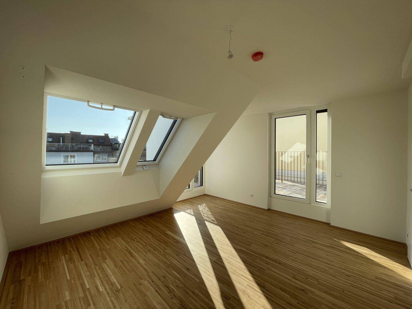 Geräumiges Schlafzimmer im Dachgeschoss mit Parkettboden, viel Tageslicht und Terrassenzugang.
