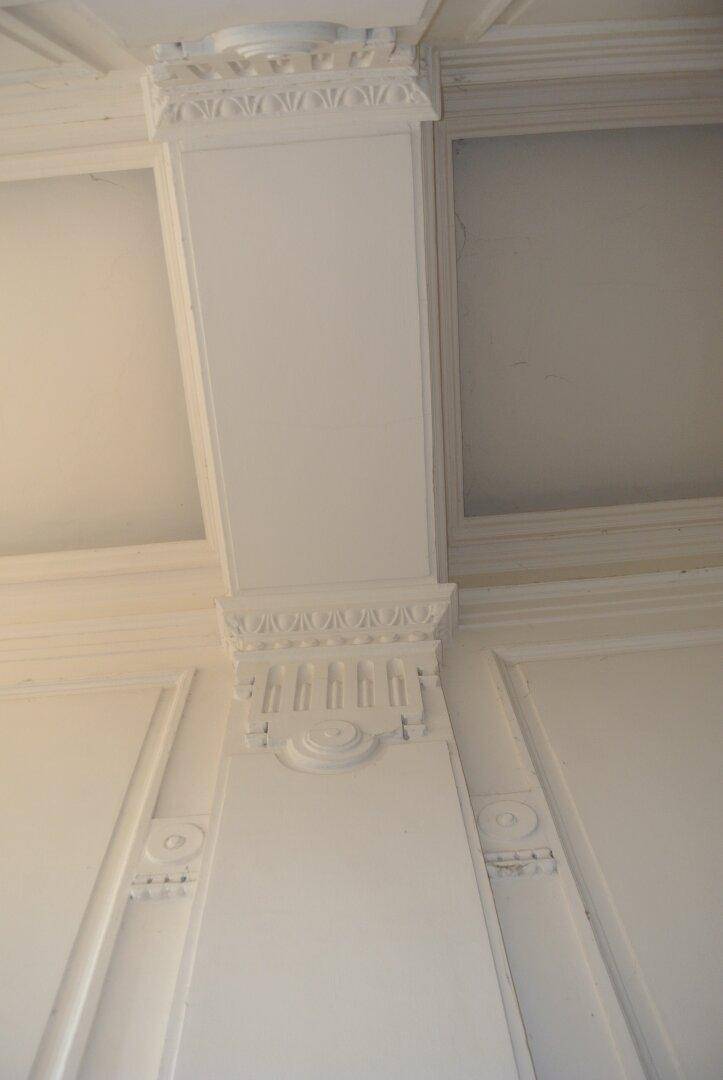 Detailaufnahme von aufwendigen Stuckverzierungen an Wand und Decke in einem Innenraum.
