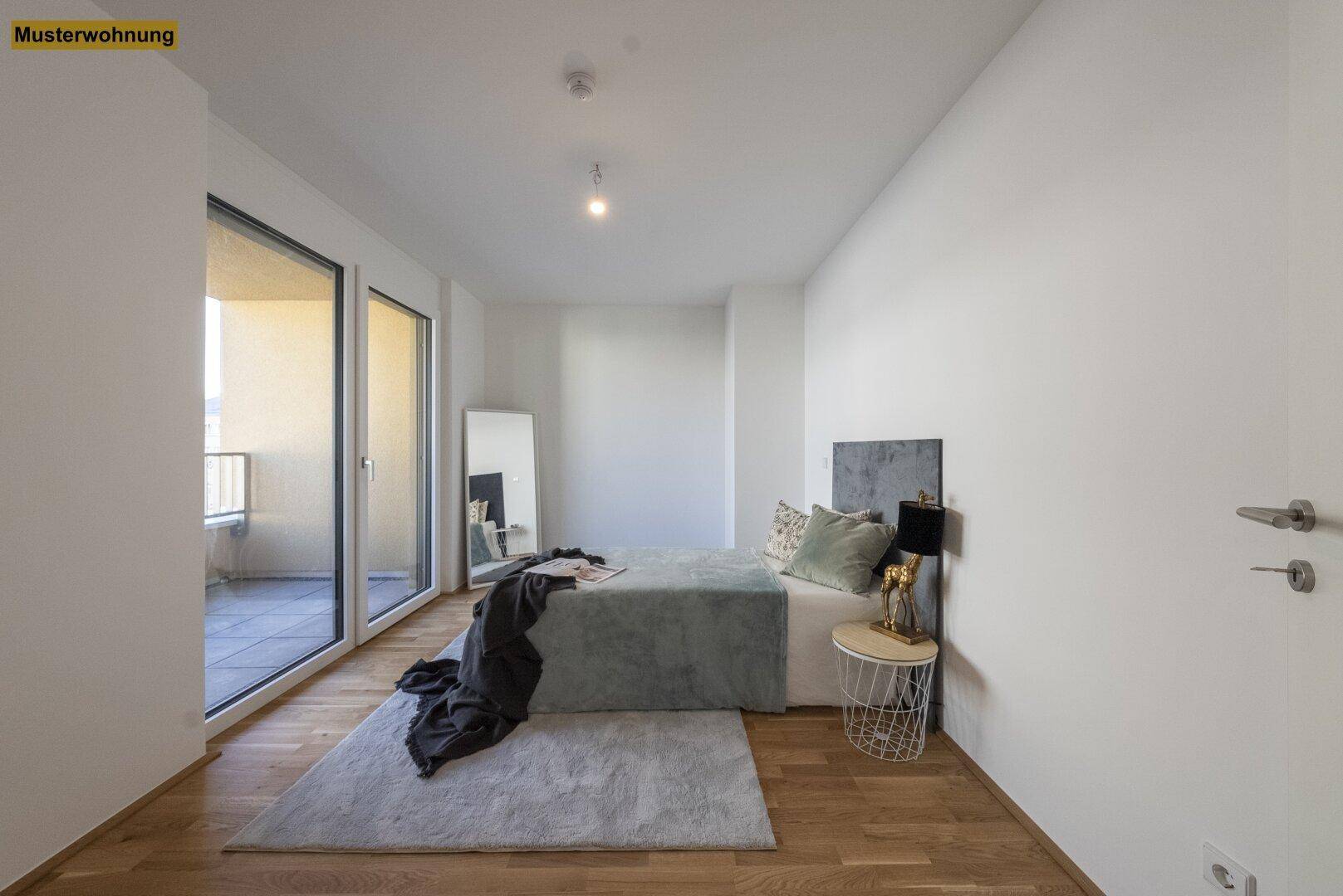 Helles Schlafzimmer mit Holzboden, großem Spiegel und direktem Zugang zum Balkon.