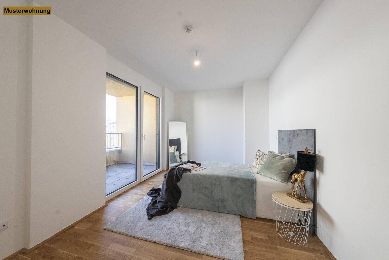 Helles Schlafzimmer mit Holzboden, modernem Bett und direktem Zugang zum Balkon.