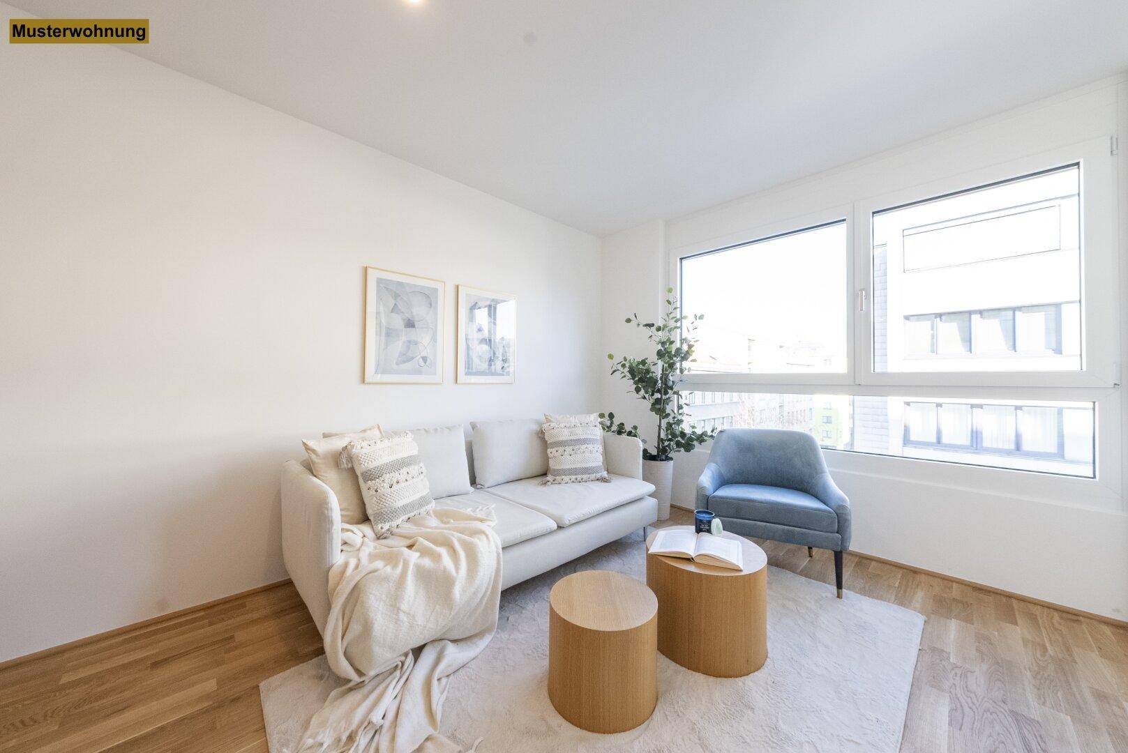 Gemütlicher Wohnbereich mit hellem Sofa, Beistelltischen und großen Fenstern für viel Licht.