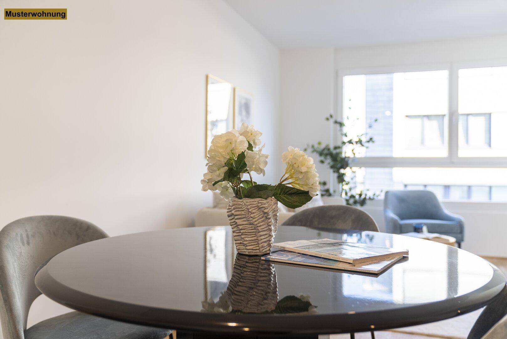 Detailansicht des modernen Esstisches mit Blumenarrangement im hellen Wohnbereich.