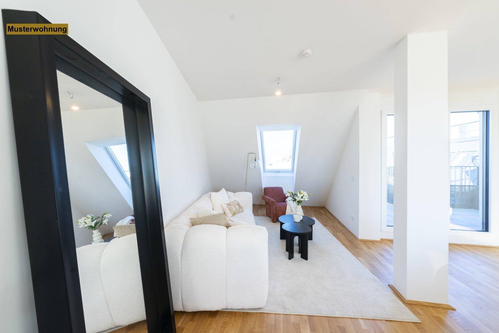 Gemütliches Wohnzimmer mit weißem Sofa, großem Spiegel und hellem Dachfenster.