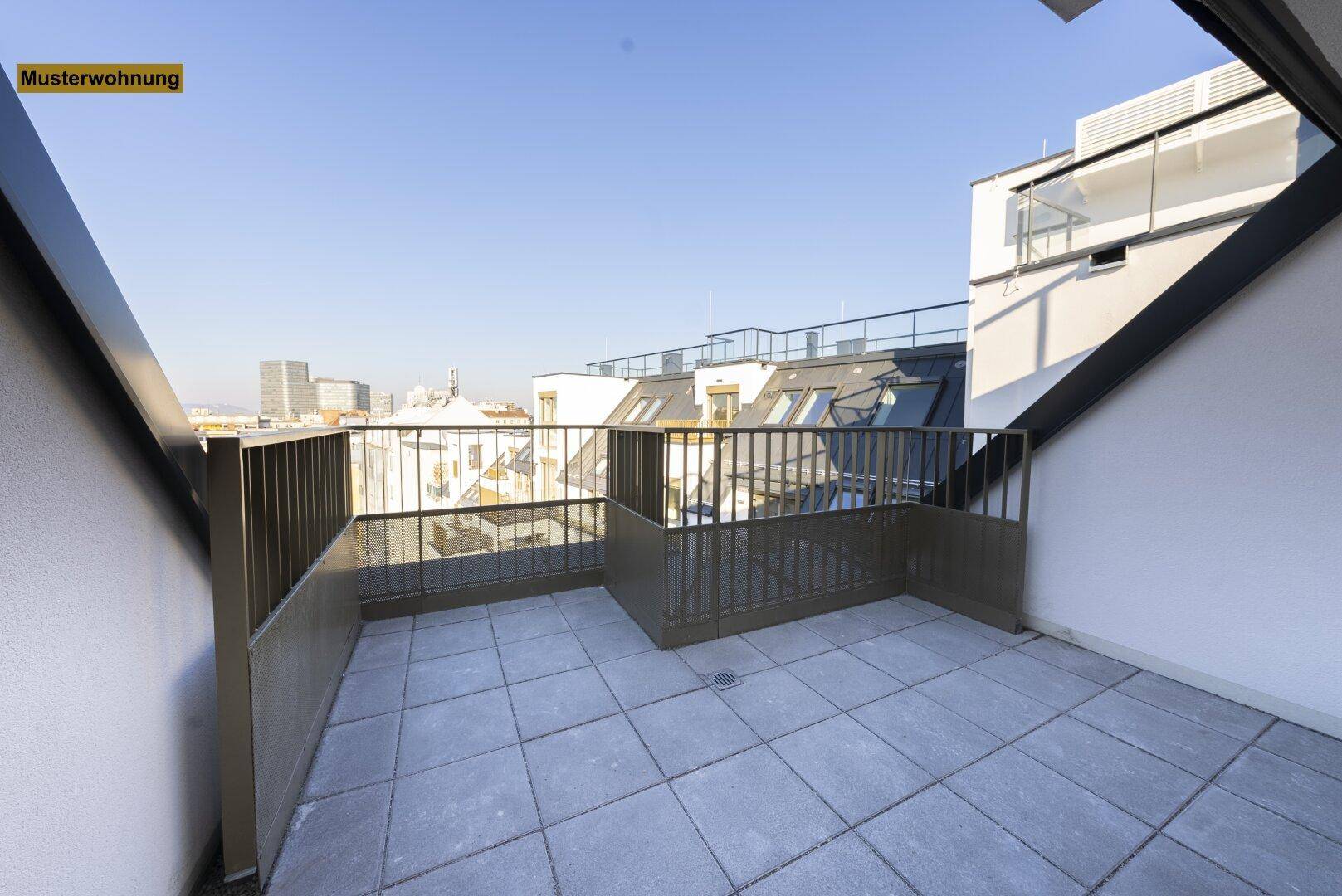 Geräumige Dachterrasse mit Fliesenboden und Metallgeländer, bietet einen weiten Blick über die Stadt.