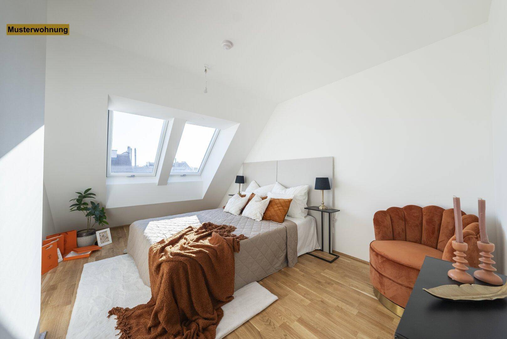 Helles Schlafzimmer mit Holzboden, Dachschrägen und zwei großen Dachfenstern, modern eingerichtet.