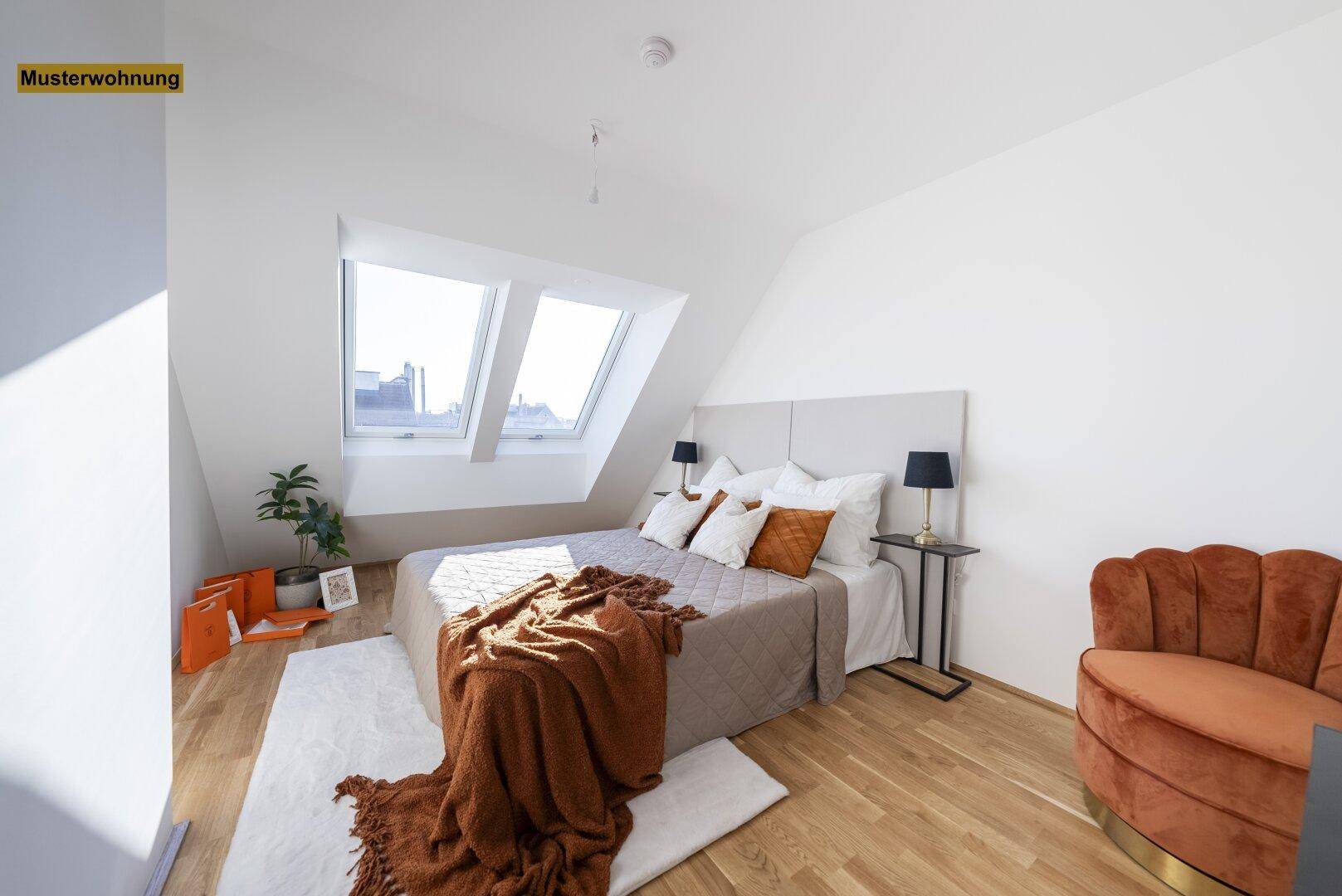Modernes Schlafzimmer mit Holzboden, Dachschrägen und zwei Dachfenstern, die viel Helligkeit spenden.