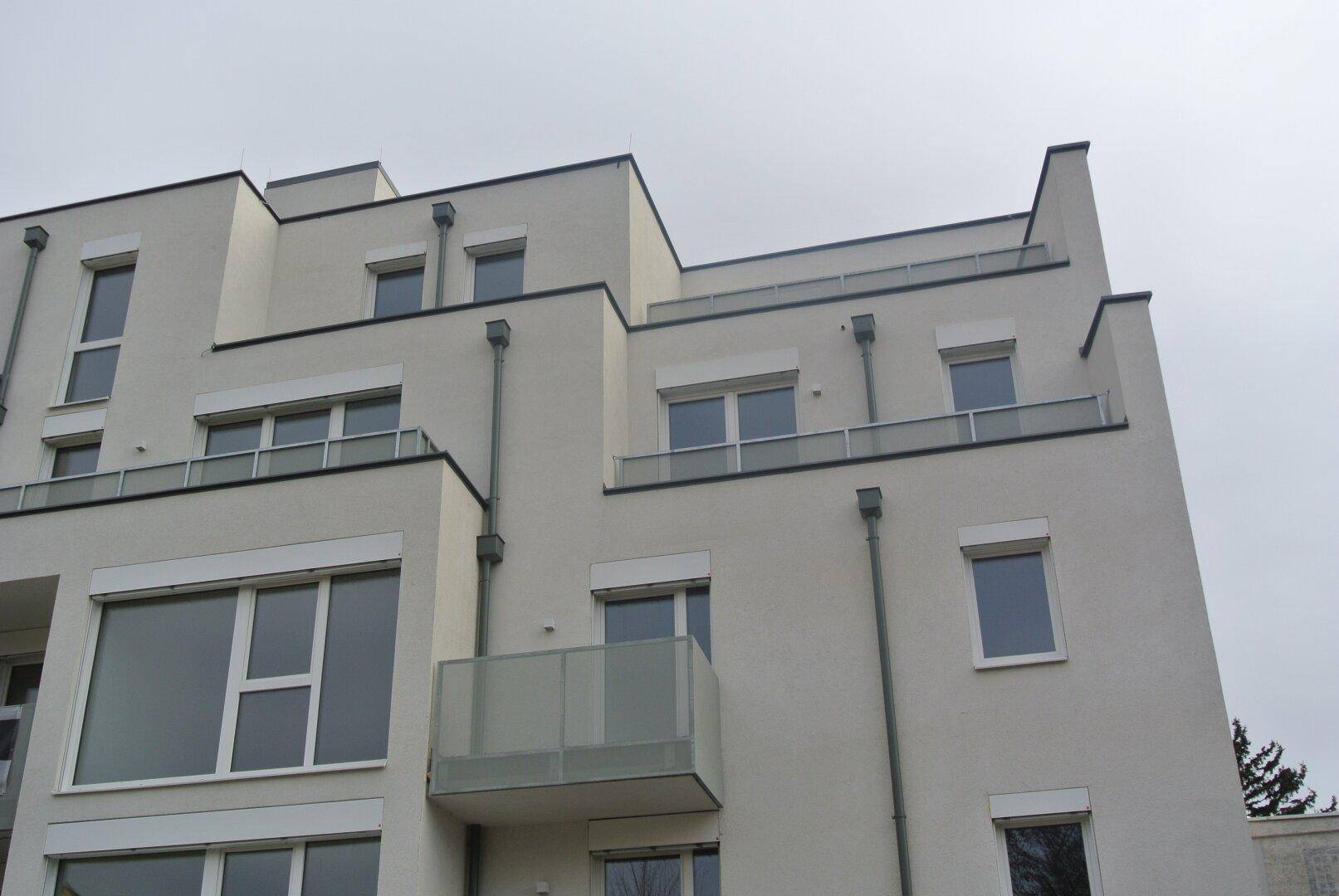 Ansicht der modernen Gebäudefassade mit mehreren Balkonen und großen Fensterfronten.