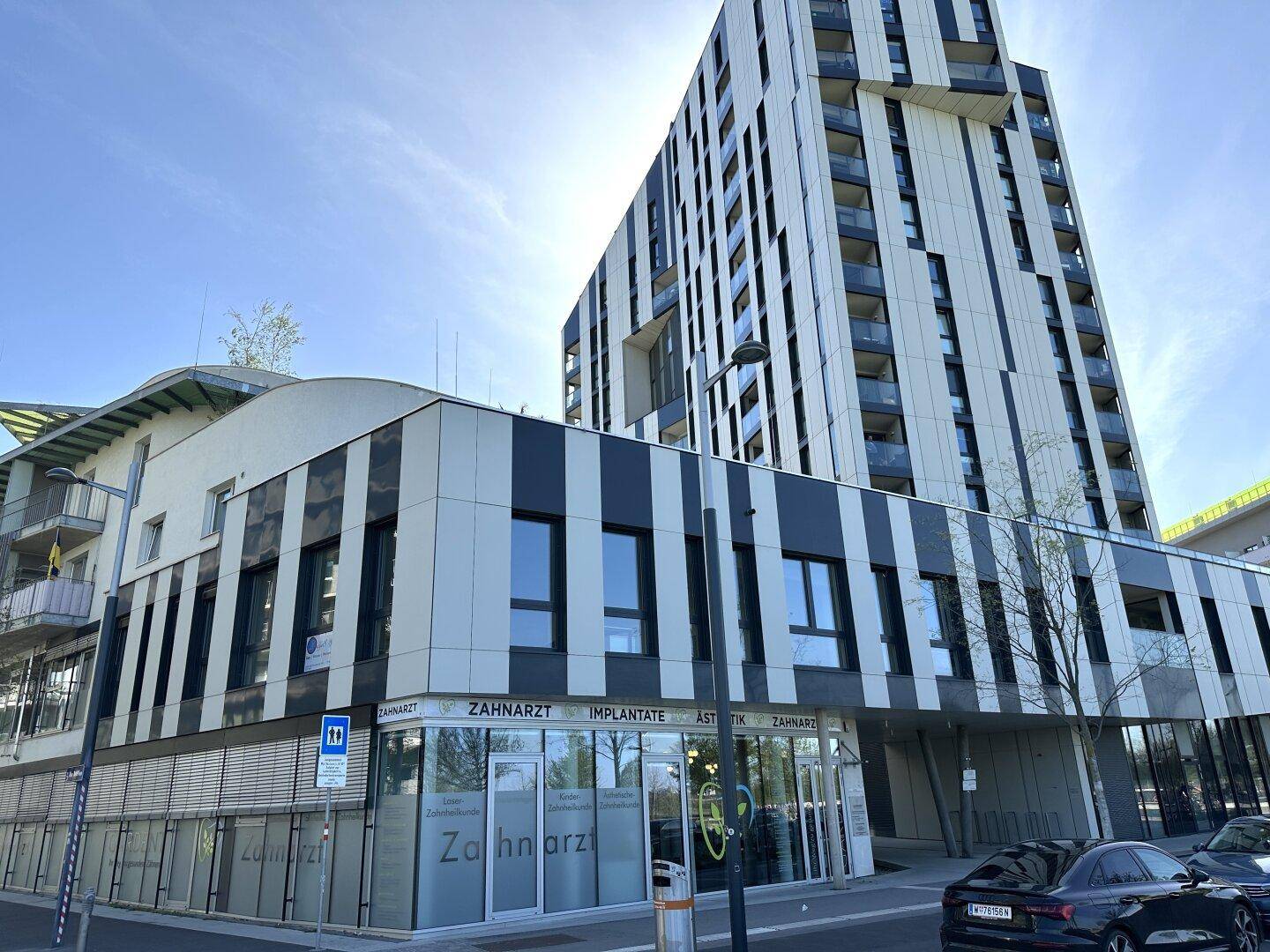 Modernes Geschäftsgebäude mit markanter schwarz-weißer Fassade und angrenzendem Hochhaus.