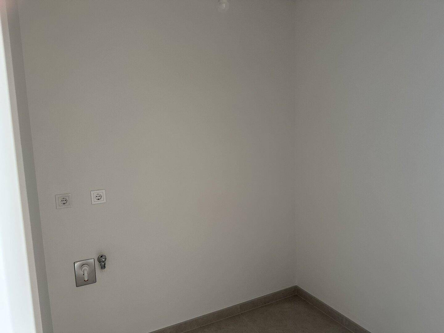 Praktischer Hauswirtschaftsraum mit Anschlüssen für Waschmaschine und Trockner.