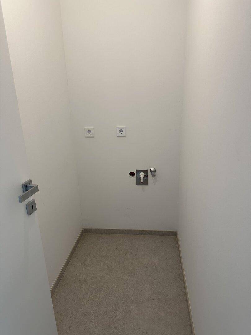 Kleiner Hauswirtschaftsraum mit Anschlüssen für Waschmaschine und Trockner.