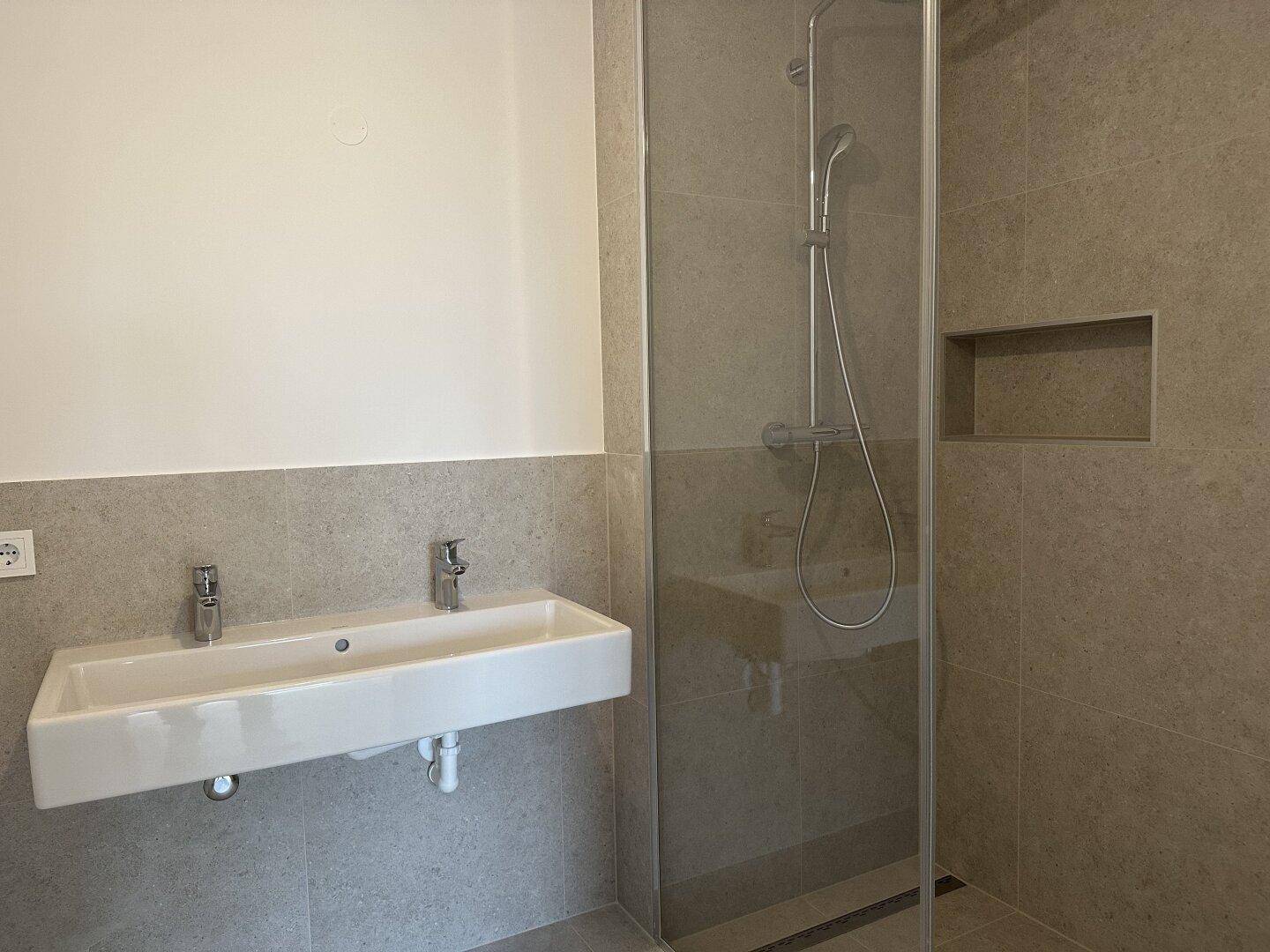 Modernes Badezimmer mit Doppelwaschbecken und einer geräumigen begehbaren Dusche.