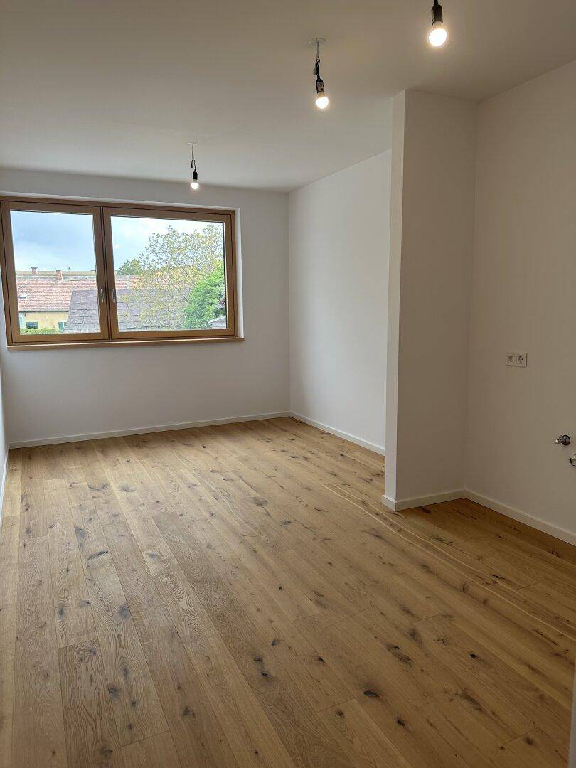 Geräumiges Zimmer mit Eichenparkettboden und einem großen Fenster für viel Tageslicht.