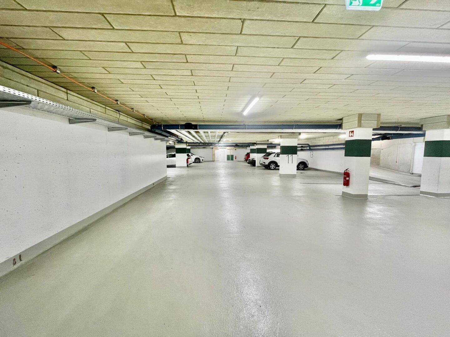 Saubere und gut beleuchtete Tiefgarage mit vielen freien Stellplätzen.